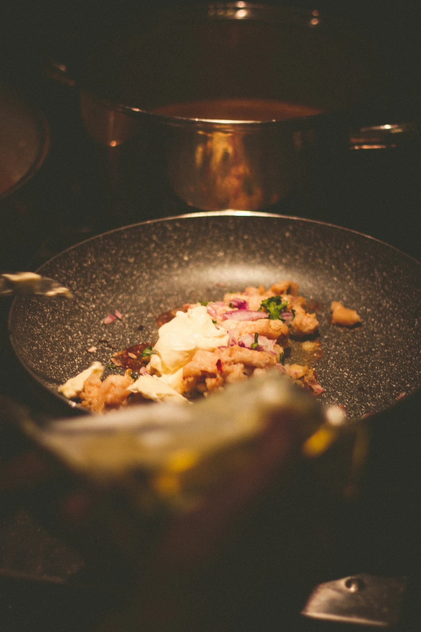 Chef Ronny preparing a dish, looking at camera smiling.