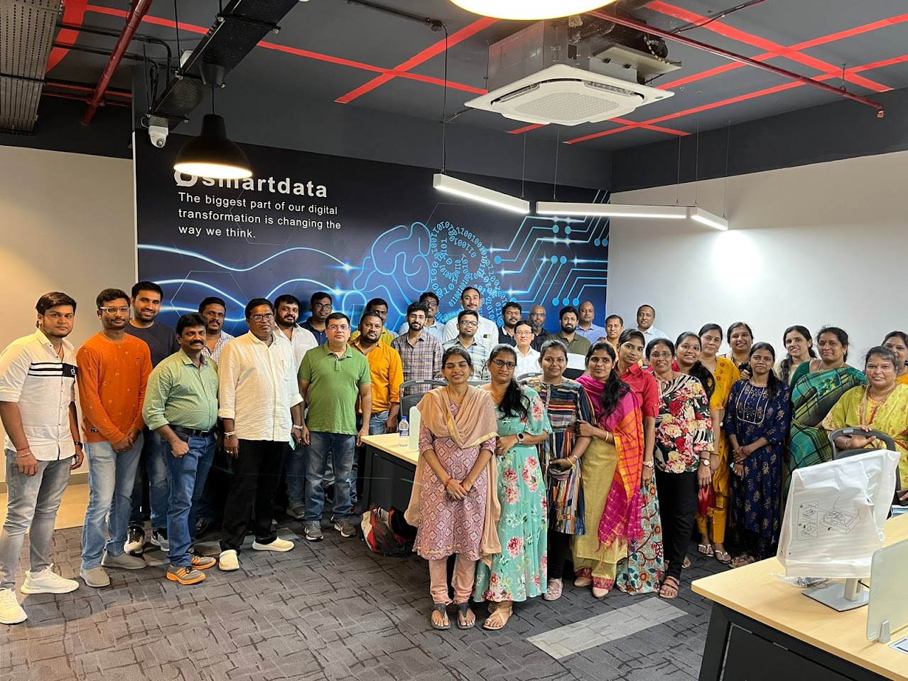 A group of people working at computer desks in a modern office environment.