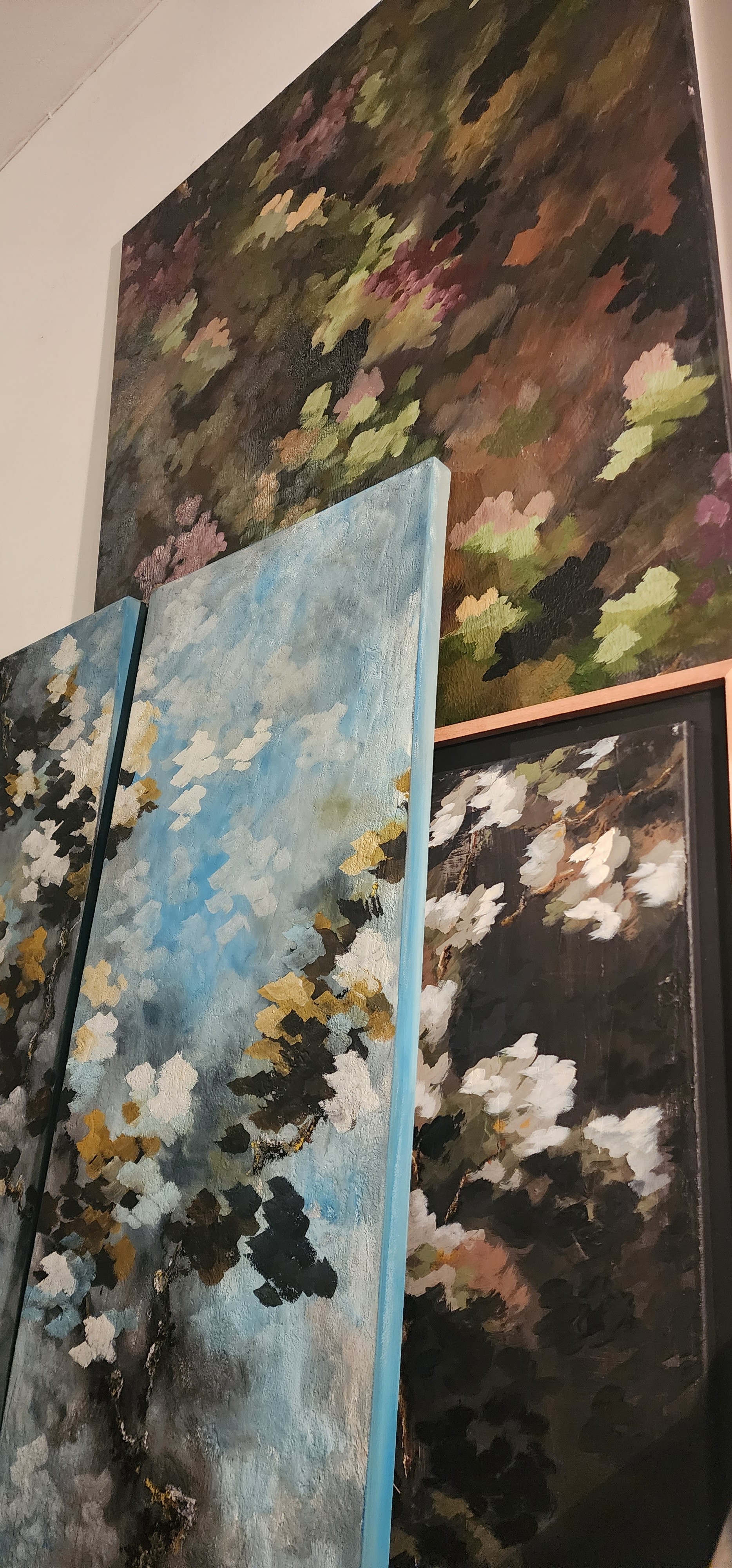 Paintings showcased next to a wall