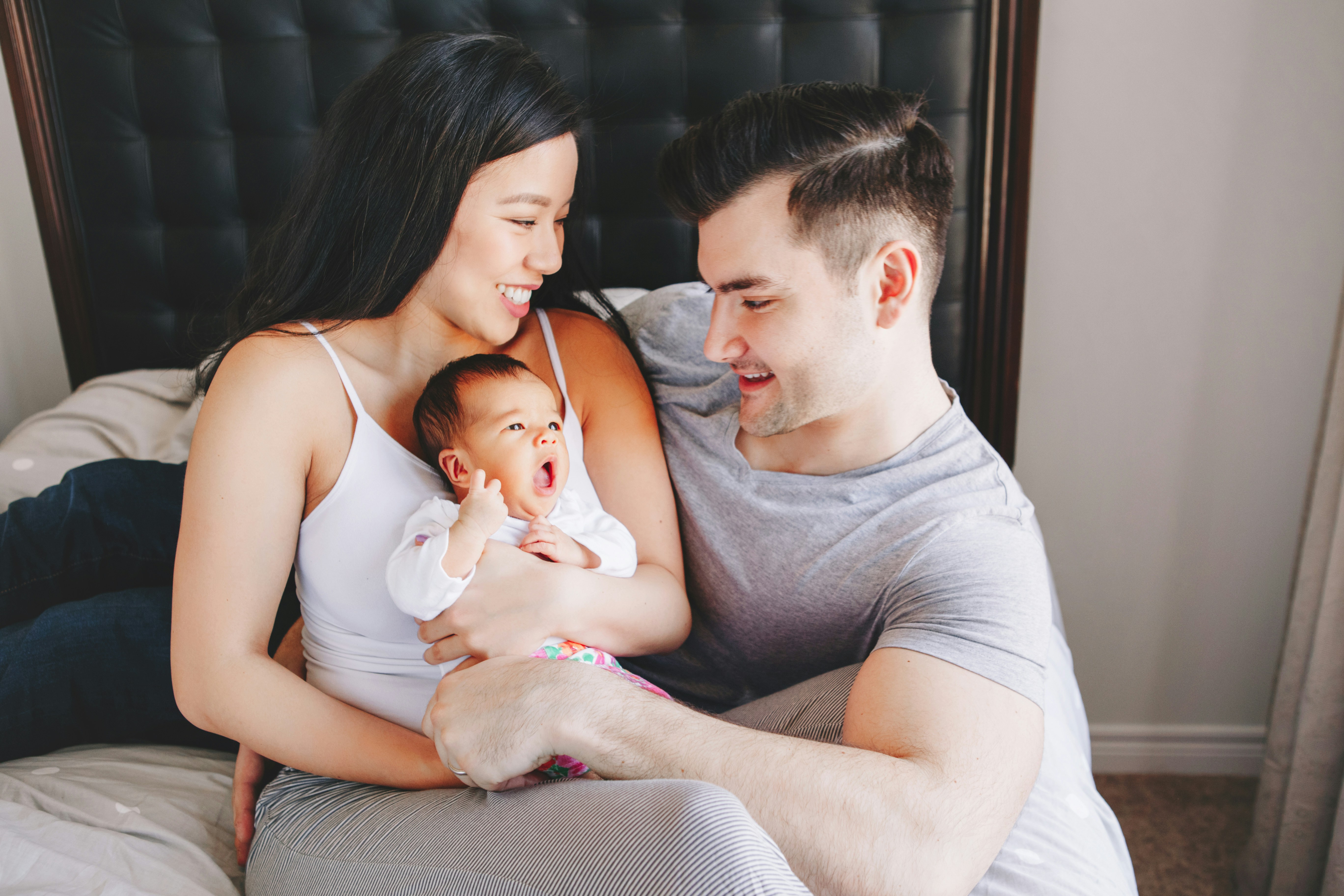 mother and father cuddling with their new baby