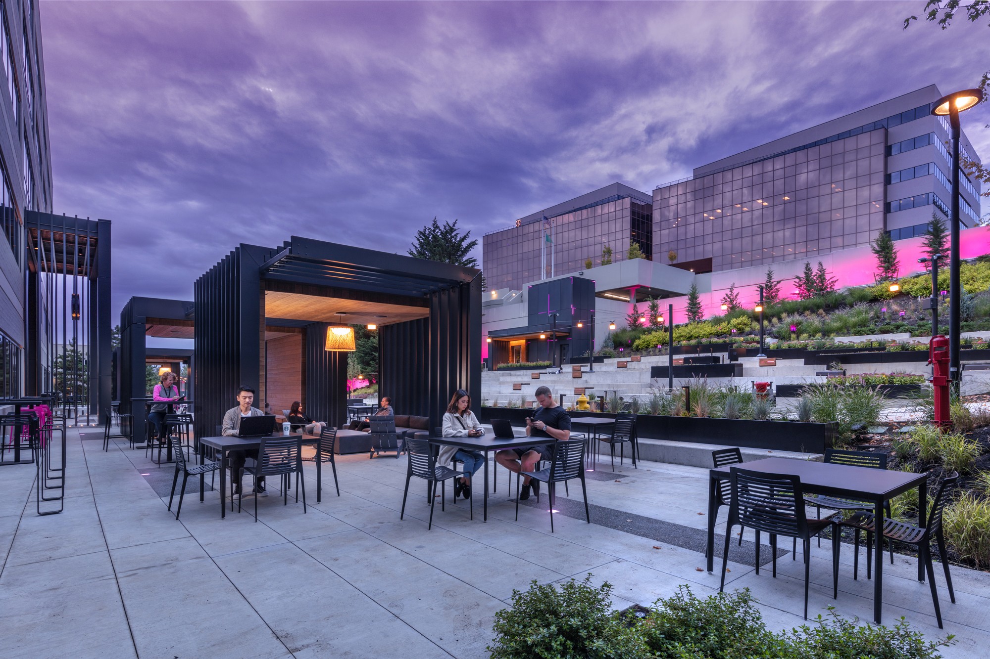 People enjoying a vibrant courtyard with diverse amenities, reflecting T-Mobile's innovative and people-first culture.