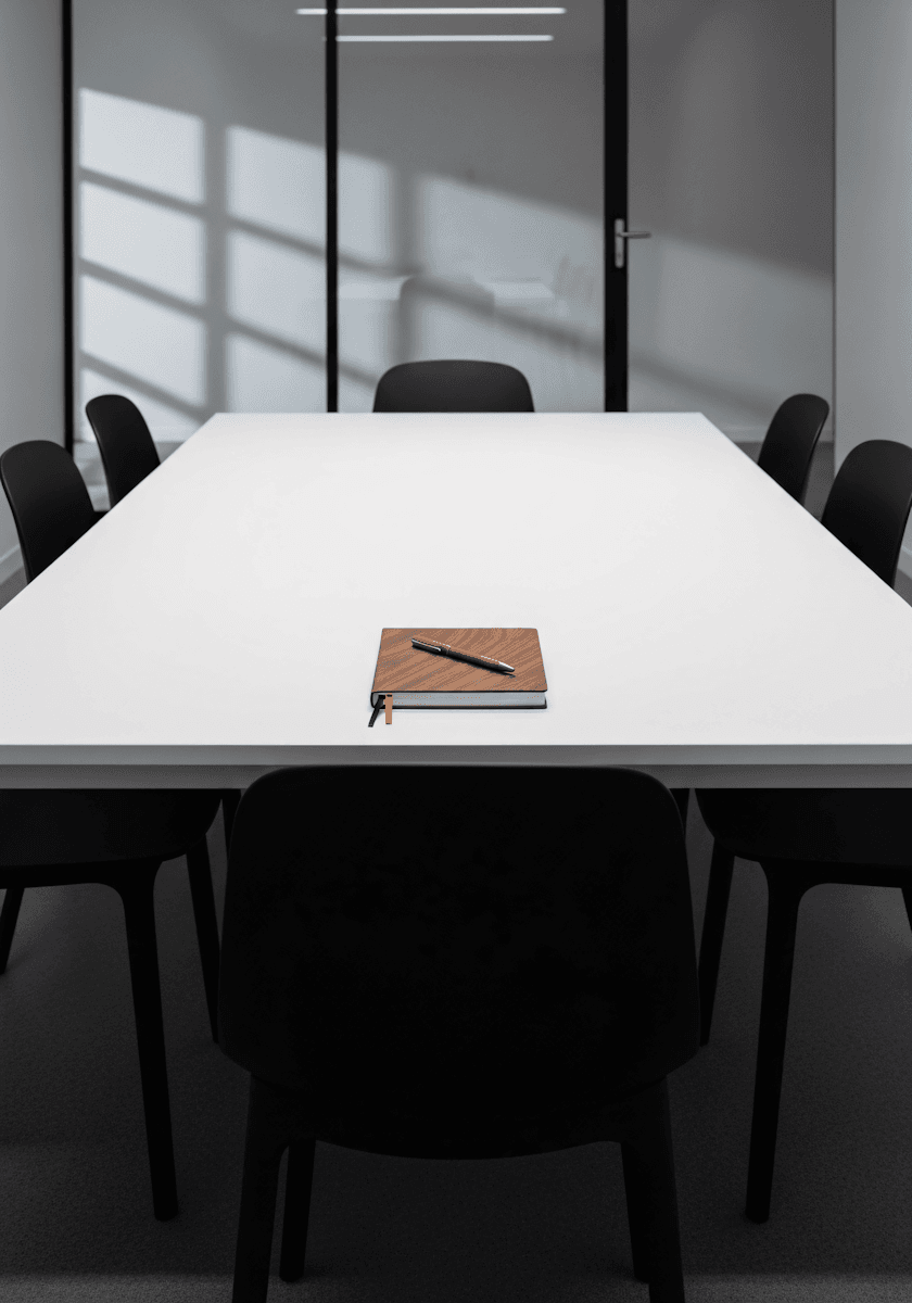 A minimalist conference room with a long white table