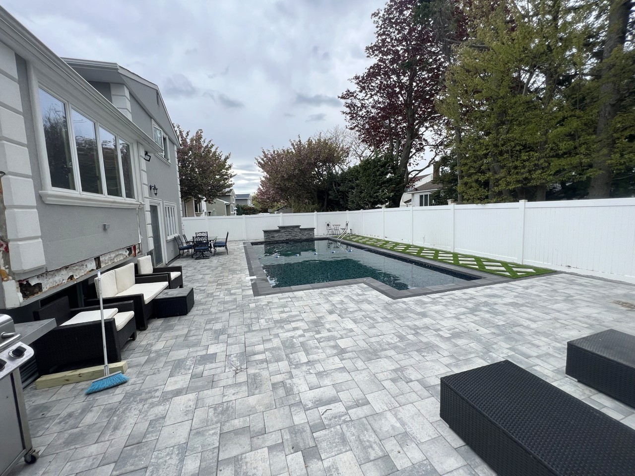 Rectangular in-ground pool with paver patio by CMC Masonry on Long Island