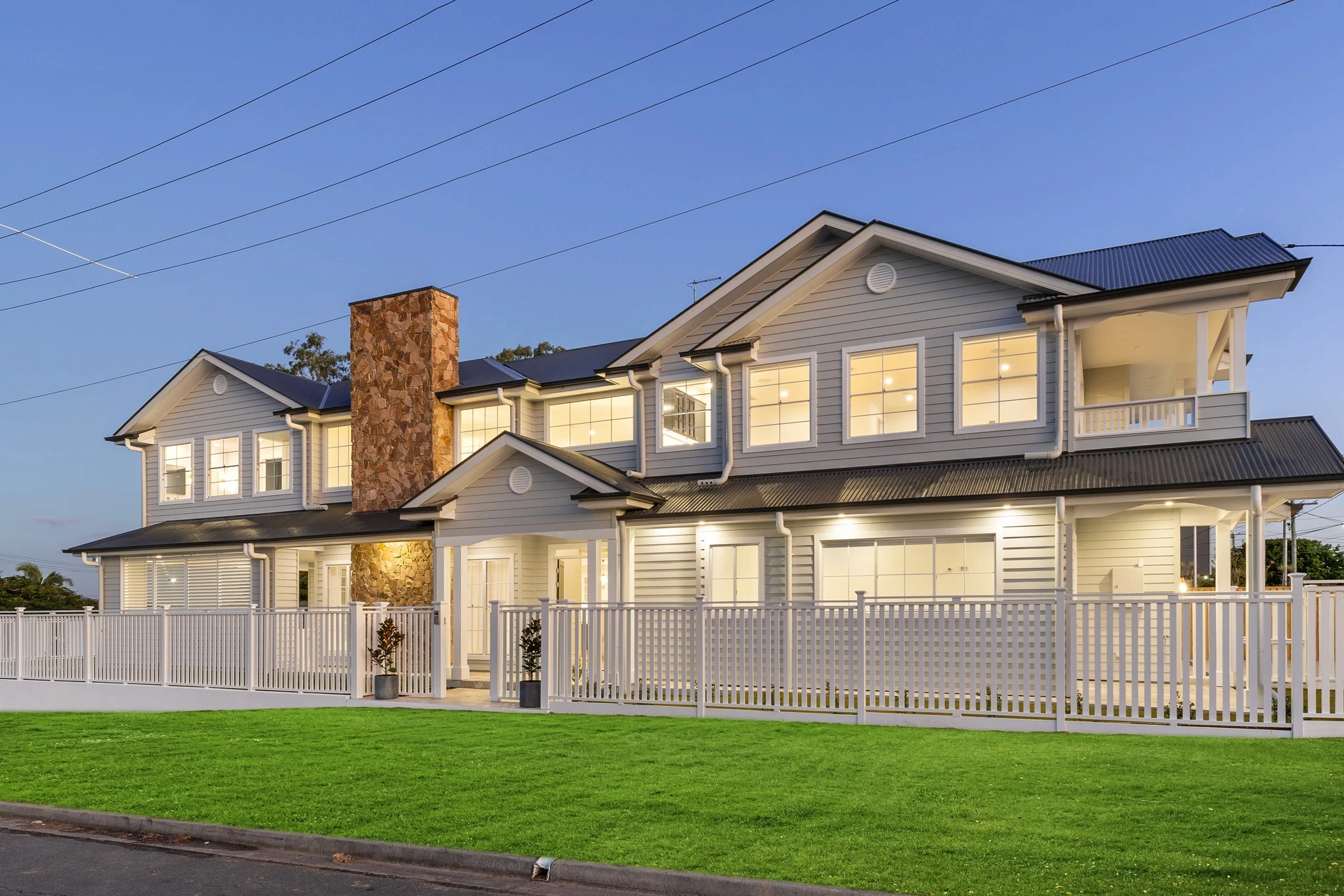 A custom Hamptons home demonstrating premium corner block house designs in Brisbane, featuring wrap-around verandahs and dual street frontages.
