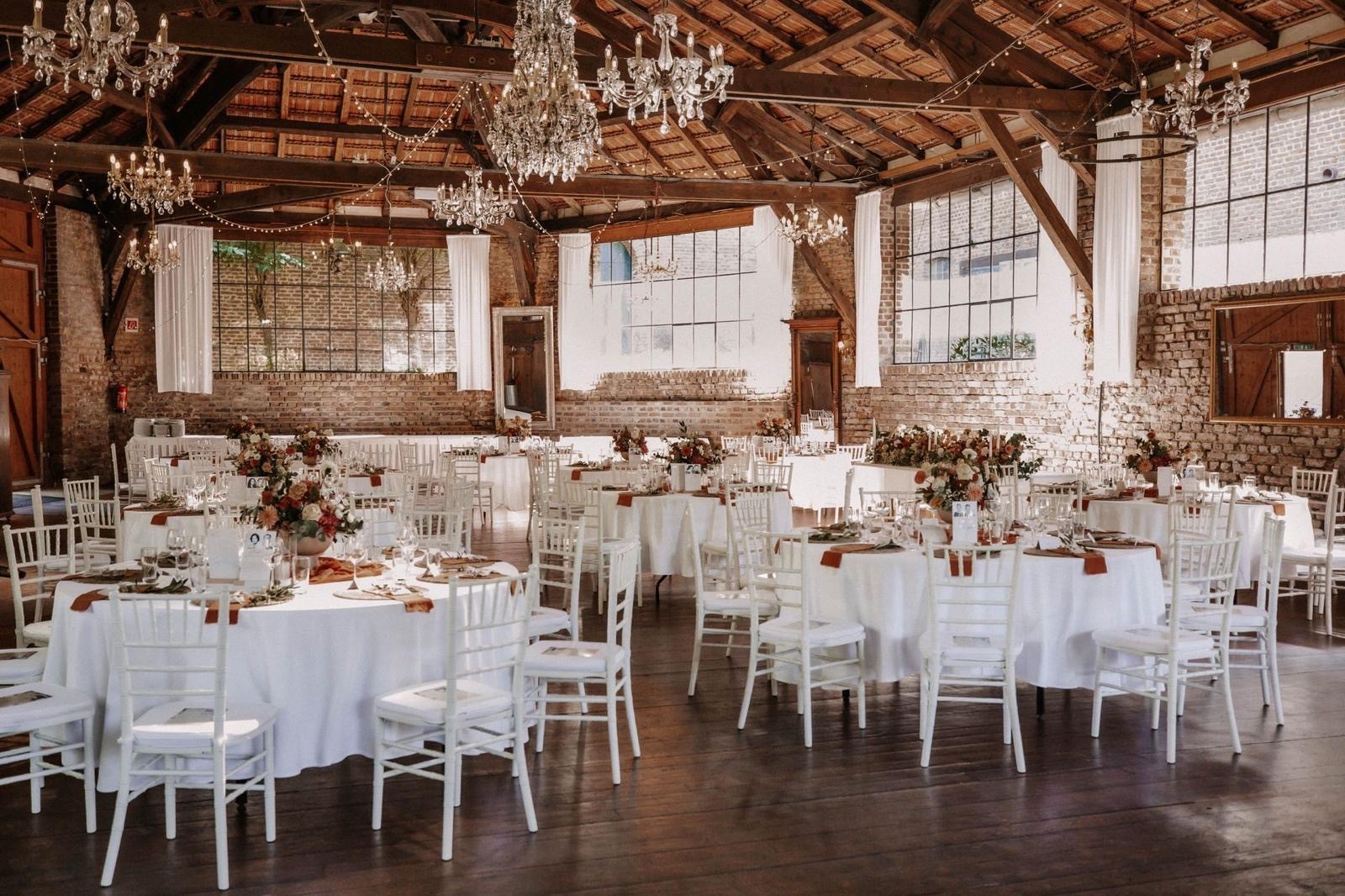 Stilvoll dekorierte Hochzeitslocation mit gedeckten Tischen