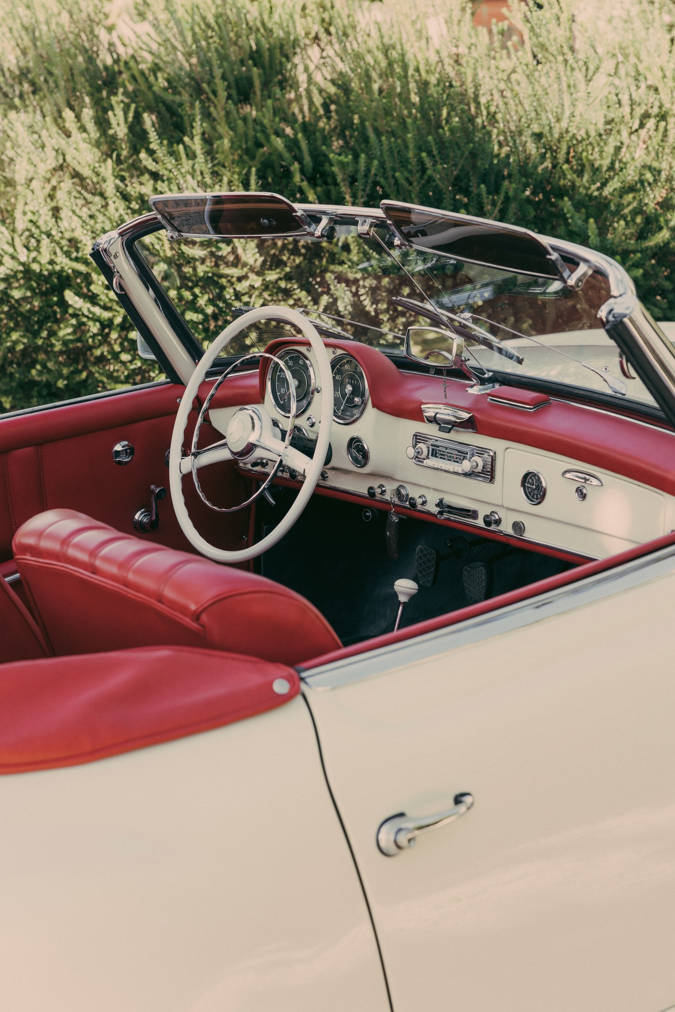 Cabriolet vintage rossa e bianca tra i vigneti di Bolgheri, dettaglio del reportage matrimoniale di Silvia e Lucio