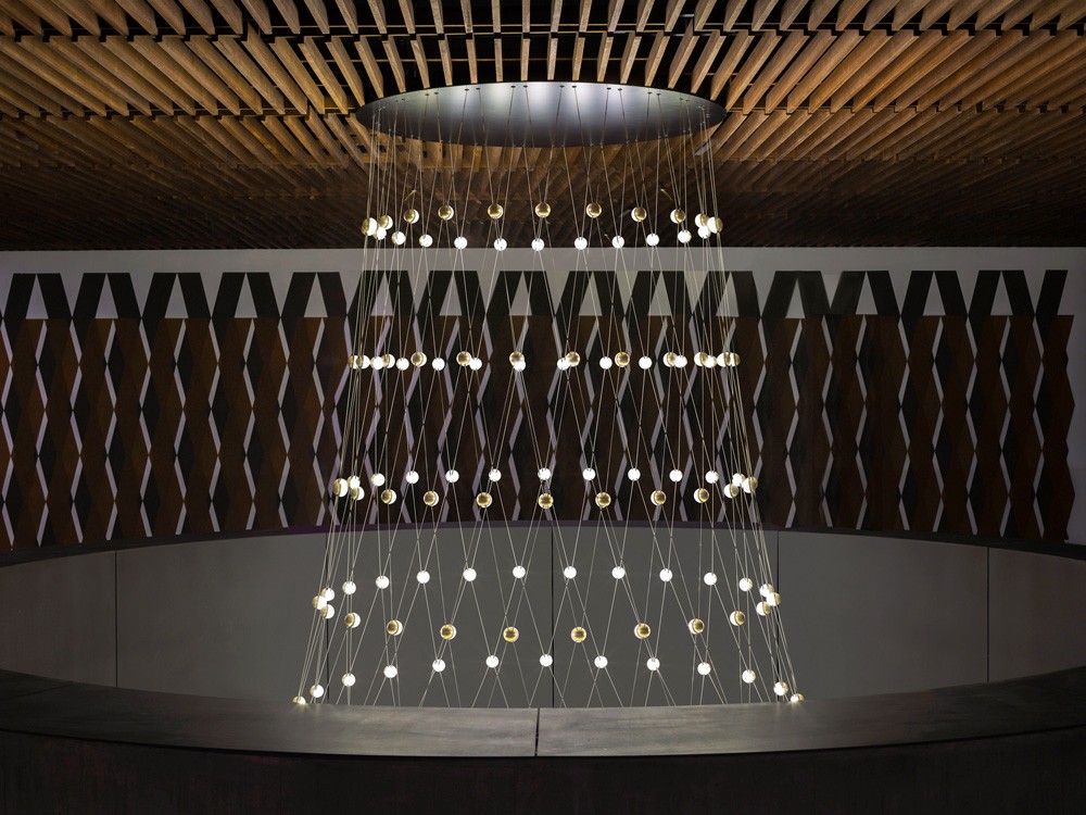 Side perspective of the suspended lighting installation at the Botswana Innovation Hub, showcasing the intricate cable net structure.