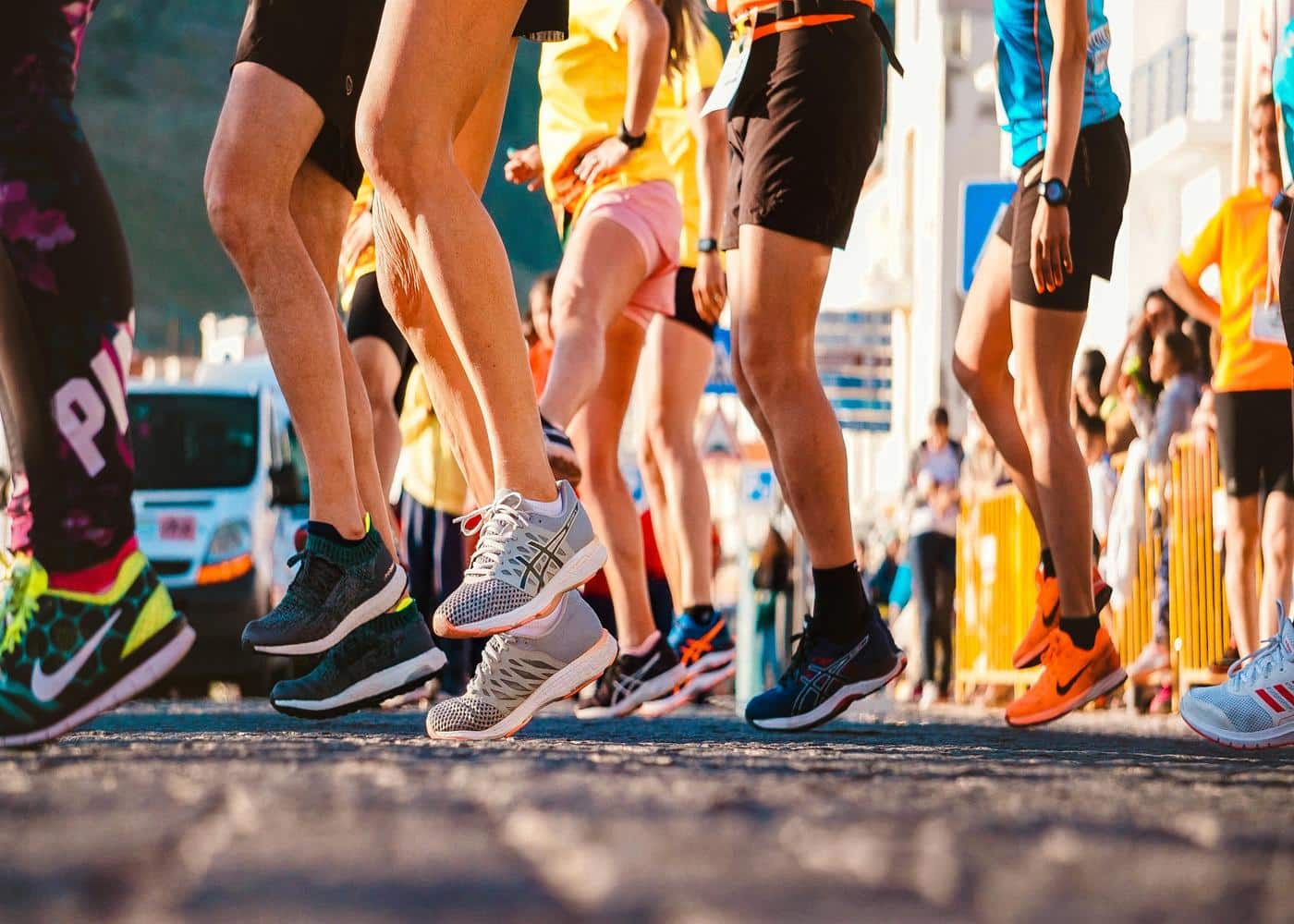 Closeup of people wearing running shoes preparing to start a marathon