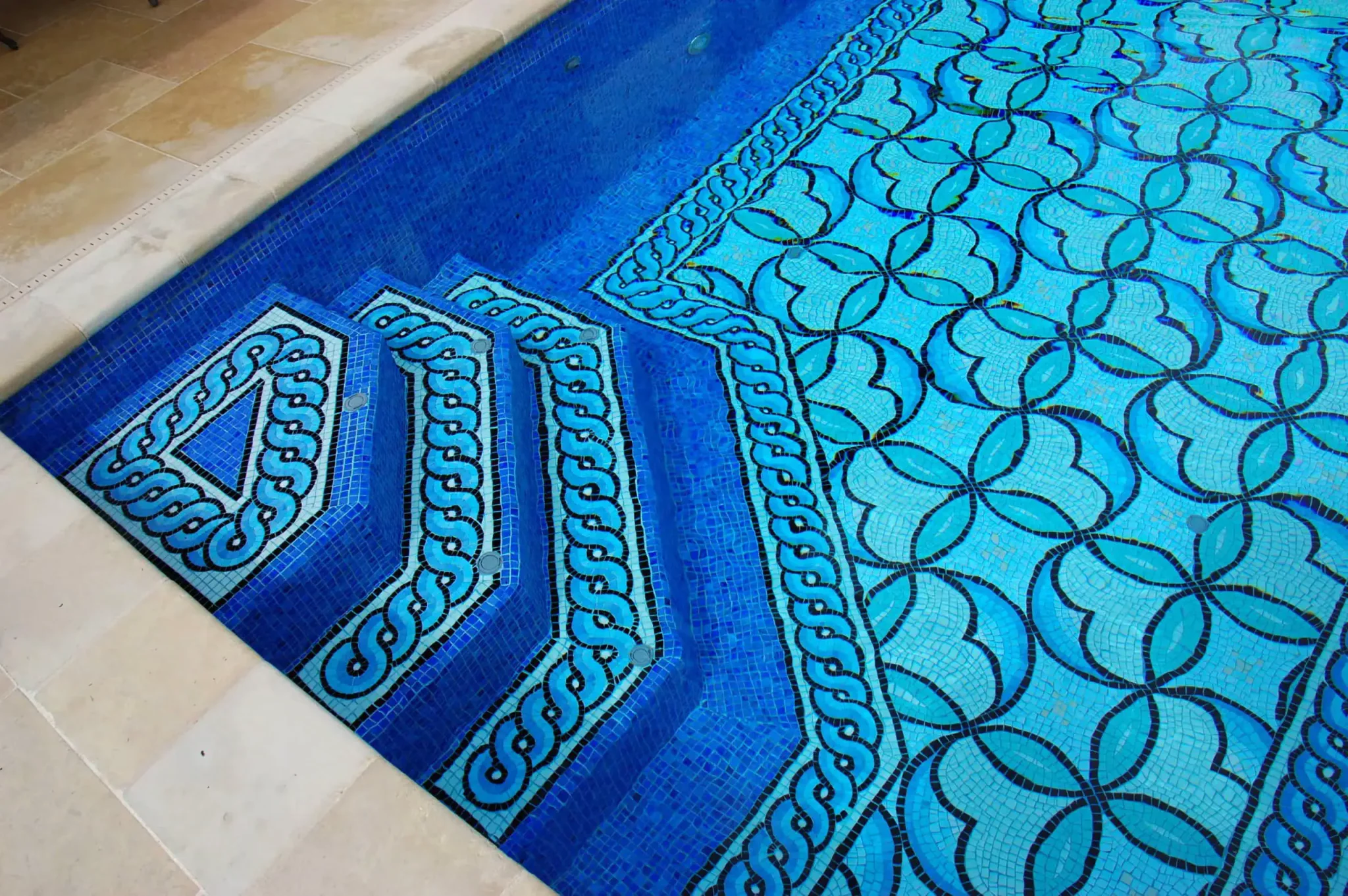 Vibrant geometric mosaic glass pool design by Mosaiclegs Art Studio on Lake Austin.