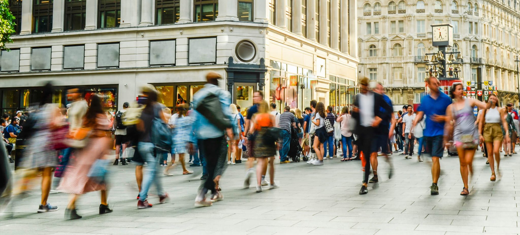 Busy high street with crowds of people walking past shops