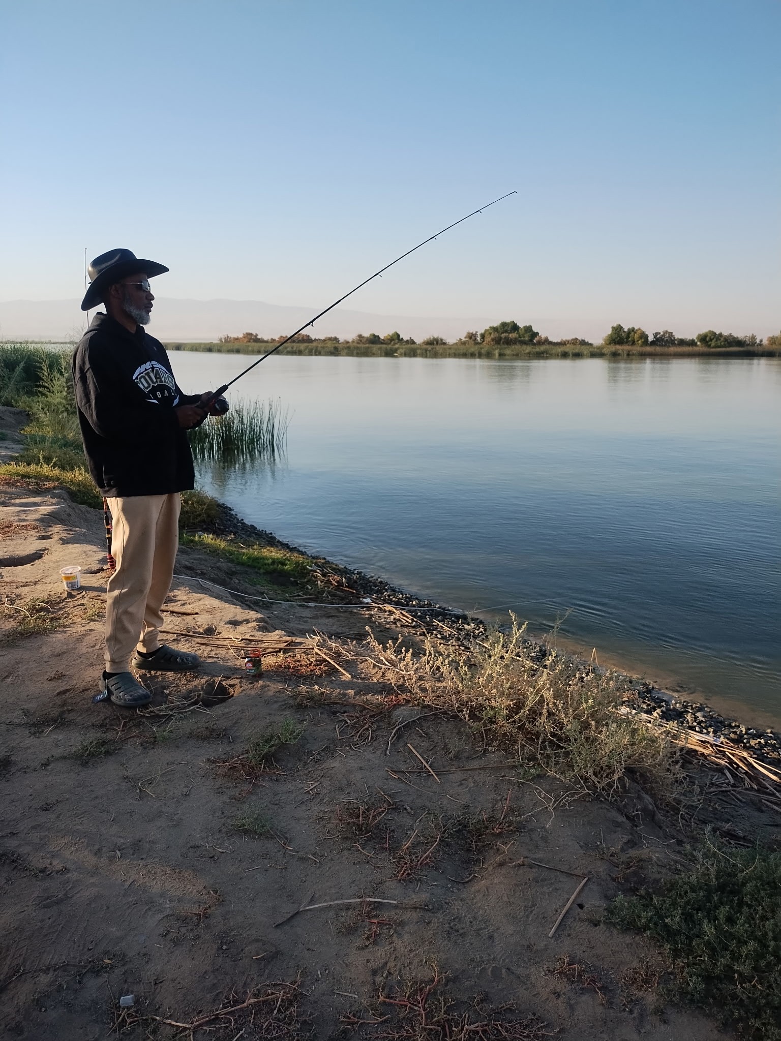 Woman siting in lotus pose meditating over a brightly lit green hill
