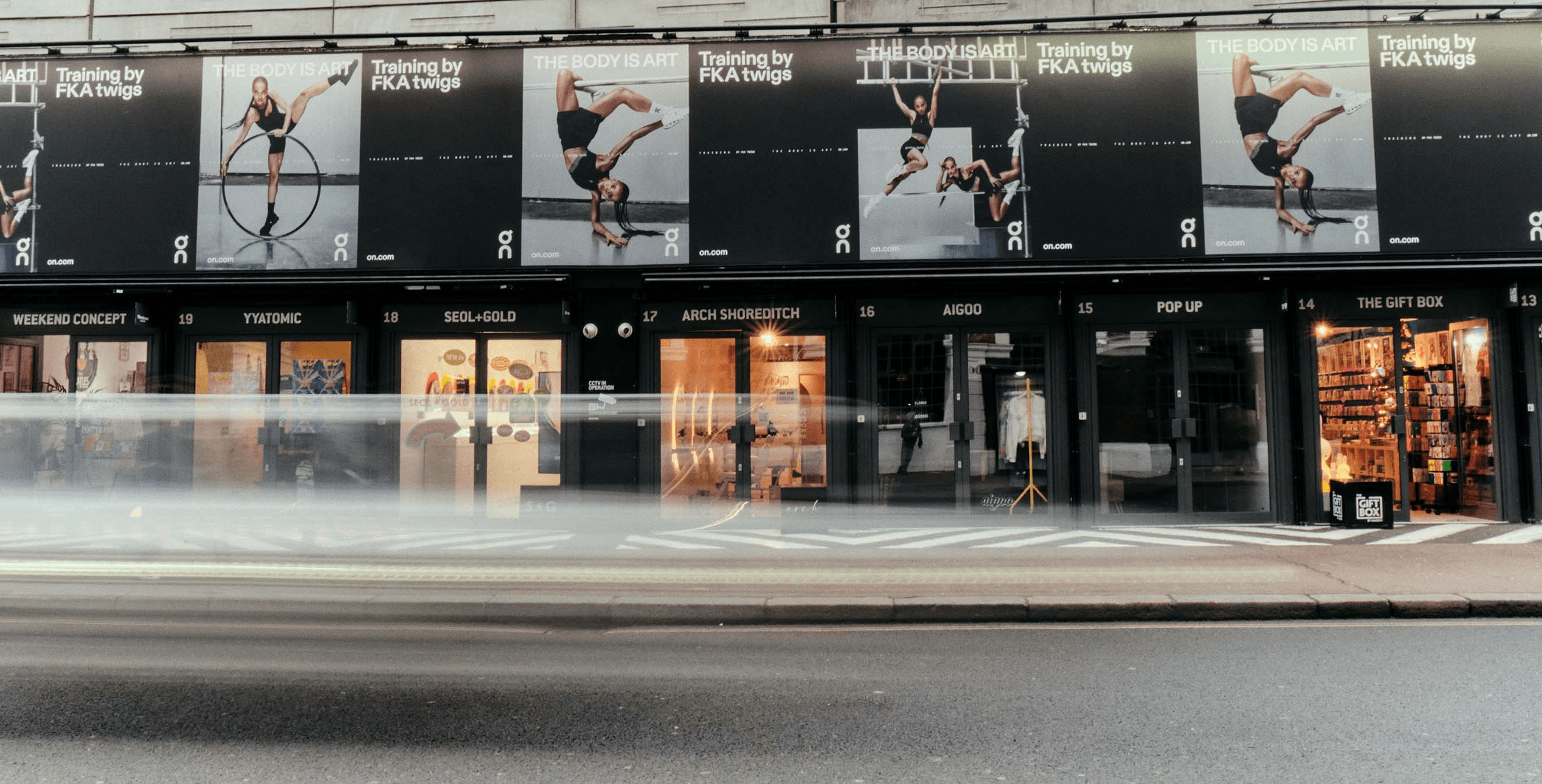 Large-scale square outdoor billboard advertisement for the On x FKA twigs campaign branding, featuring striking editorial visuals in a minimalist city setting developed by the creative studio.