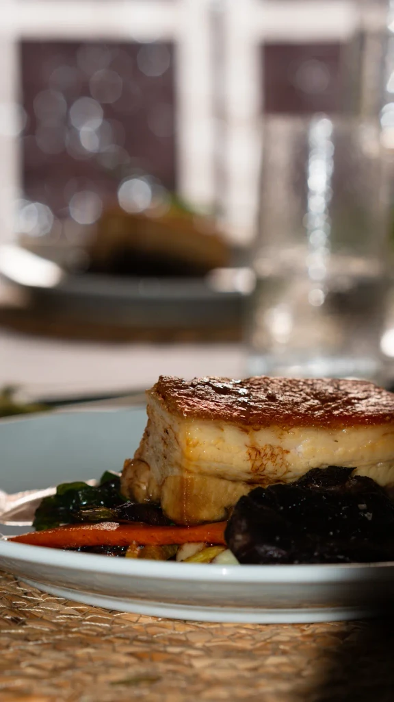 Braised pork belly served at the table by the window