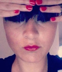 A photo of a woman holding her hair above her eyes.