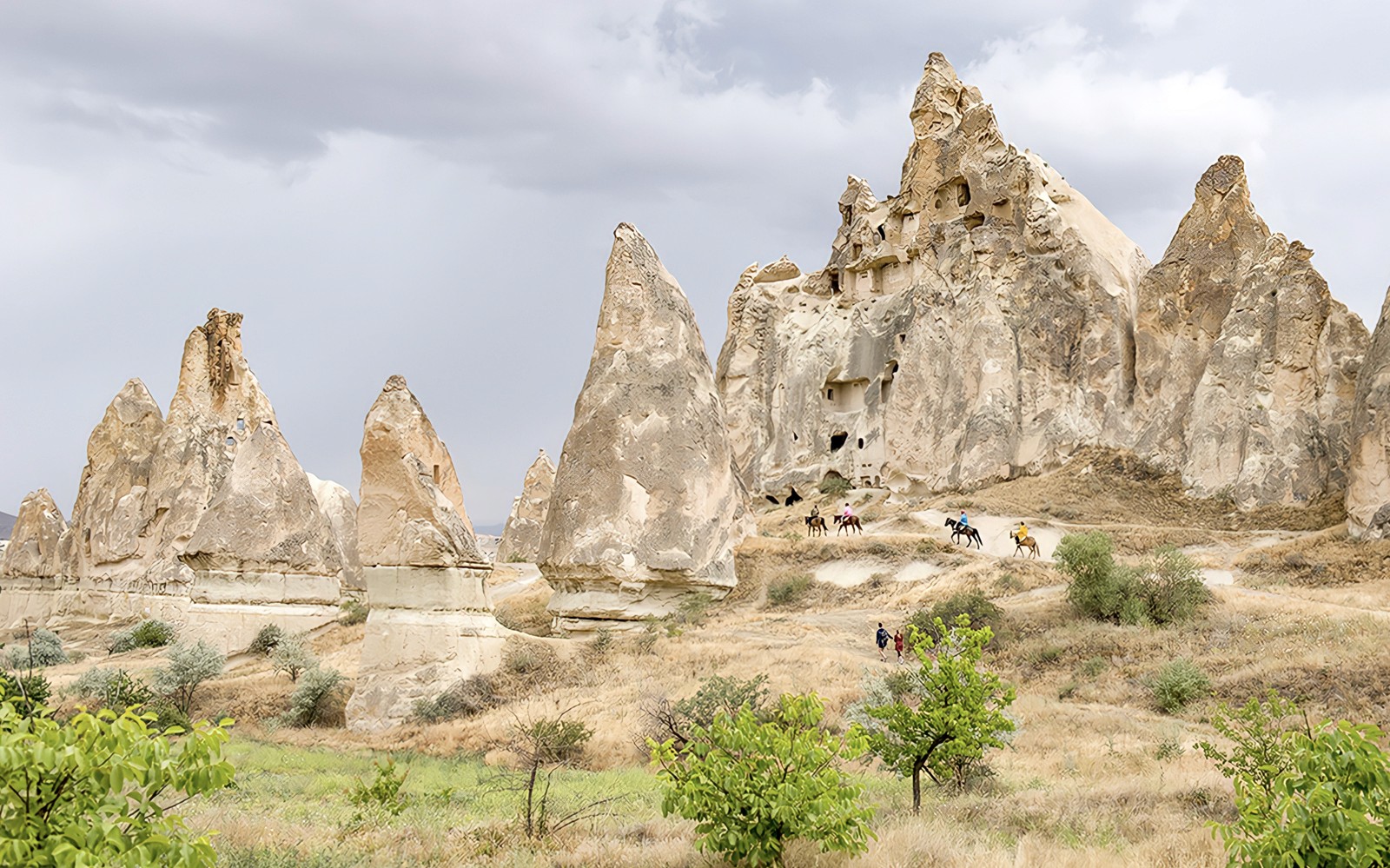 Kapadokya'nın kalbinde özel tur sırasında atlı gezginlerle Kapadokya kaya oluşumları.