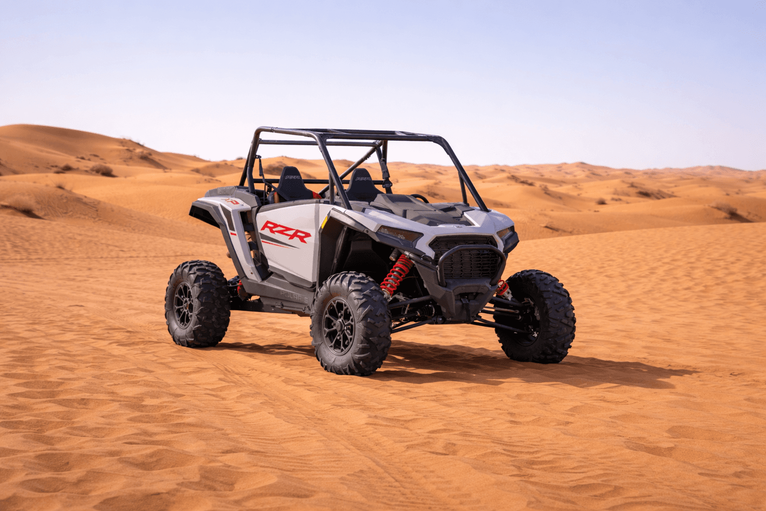 A premium Polaris RZR 1000cc XP 2-seater buggy for rent by Dune Quest Tours, parked on the scenic orange sand dunes of the Dubai desert