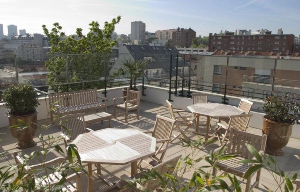 Rooftop terrace with outdoor furniture and green plants