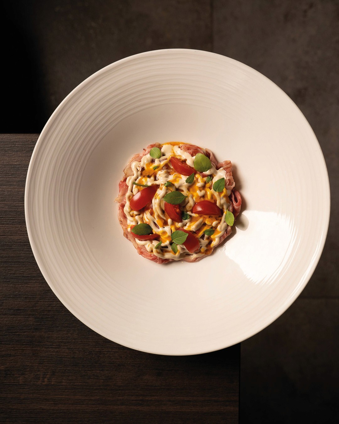 „Rinder-Carpaccio mit cremigem Dressing, Kirschtomaten und frischem Basilikum – fein abgeschmeckt und kunstvoll angerichtet im Ristorante Giuseppe Gentile.“