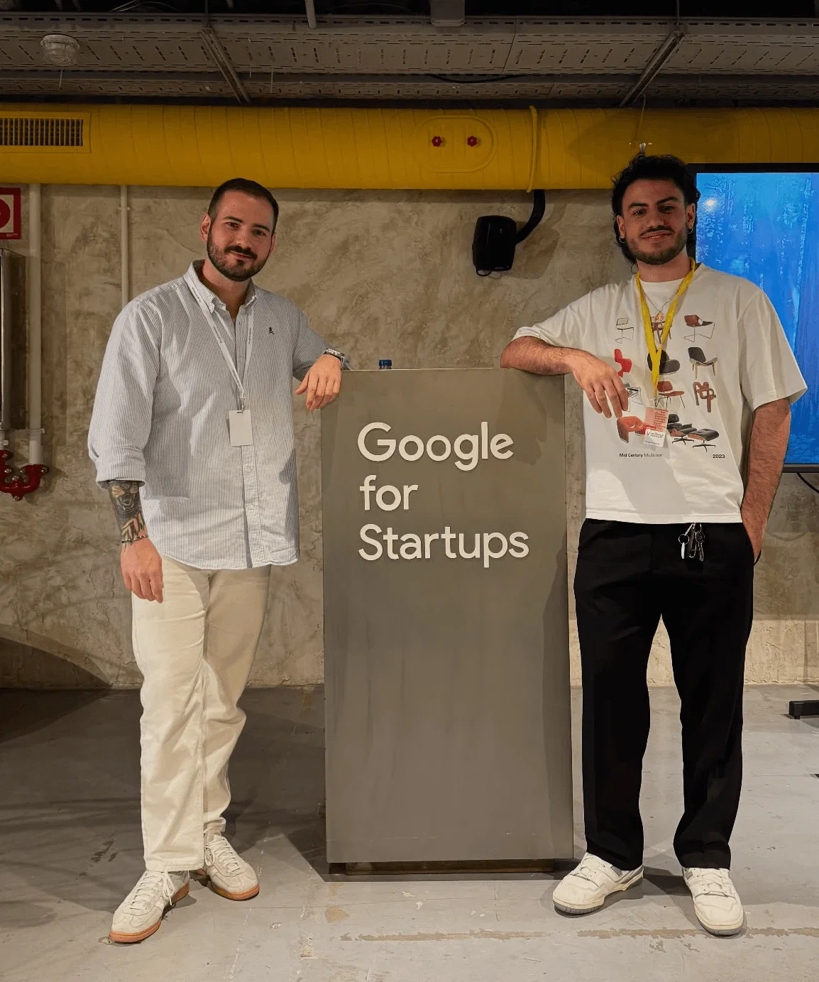 Victoriano y Hector, dueños de SocialSync están de pie junto a un cartel que dice «Google for Startups».