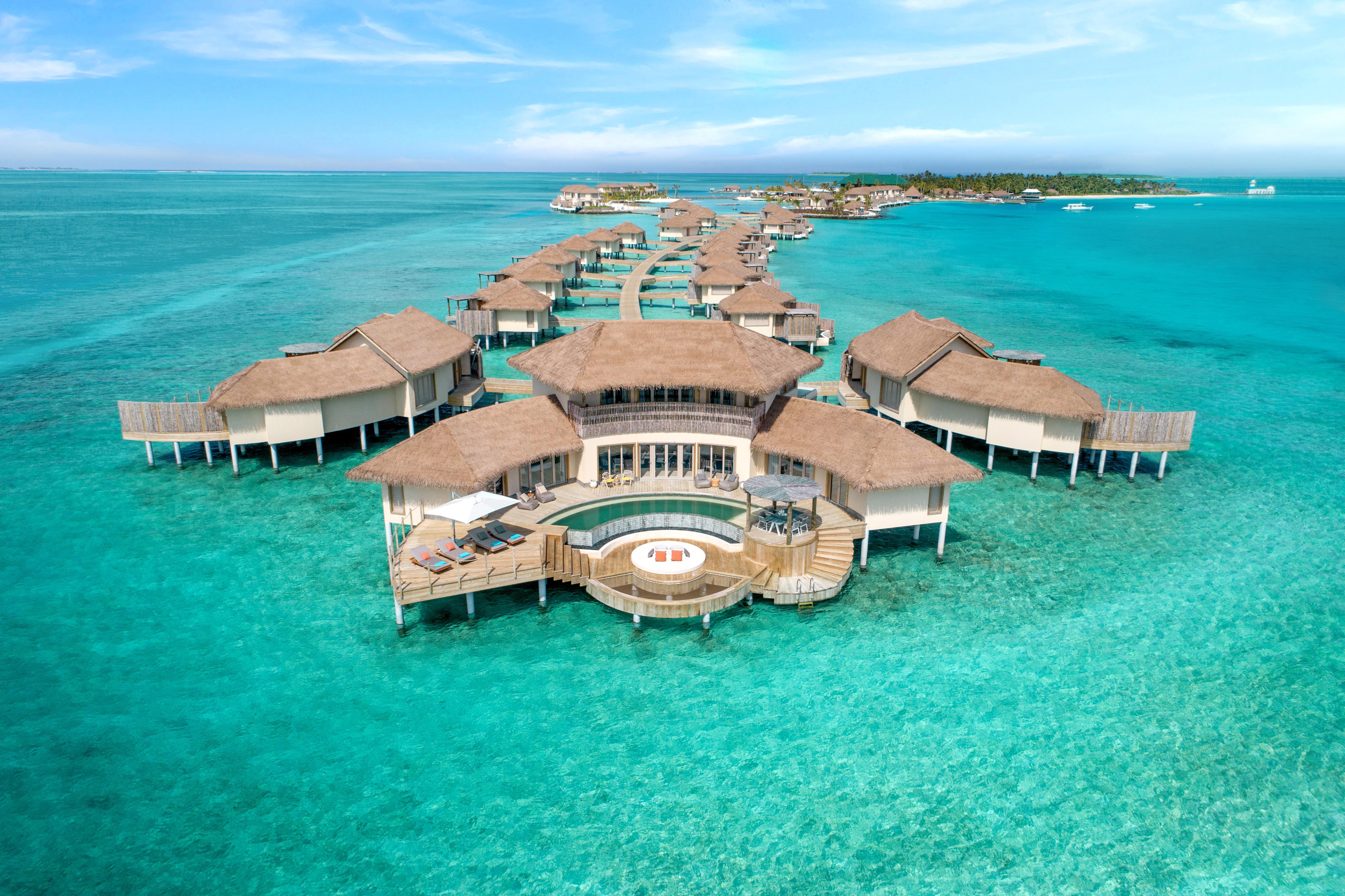 Luxury overwater villas and a private pool surrounded by crystal-clear turquoise waters in the Maldives.