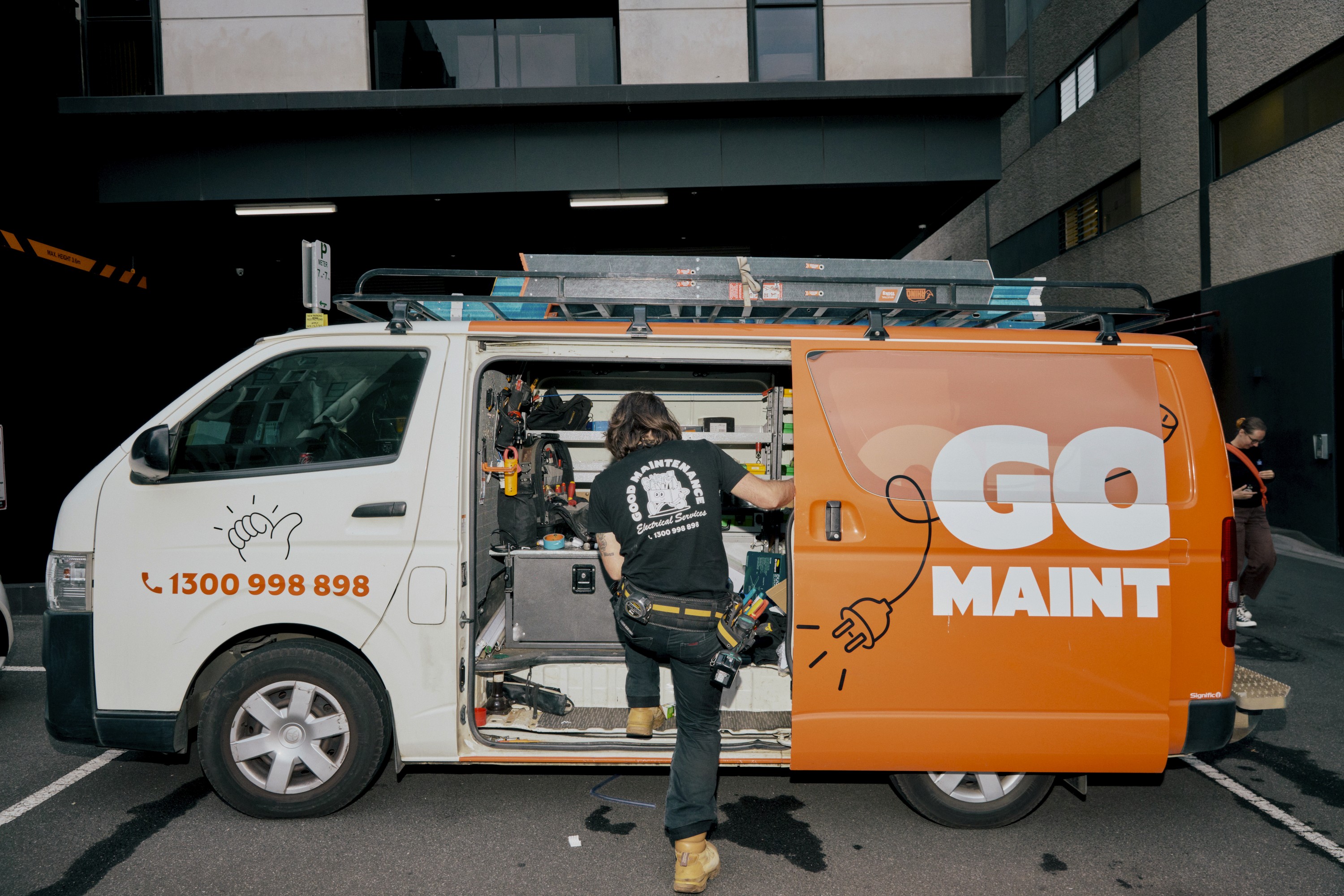 A Good Maintenance team member wearing a company shirt with graphics.