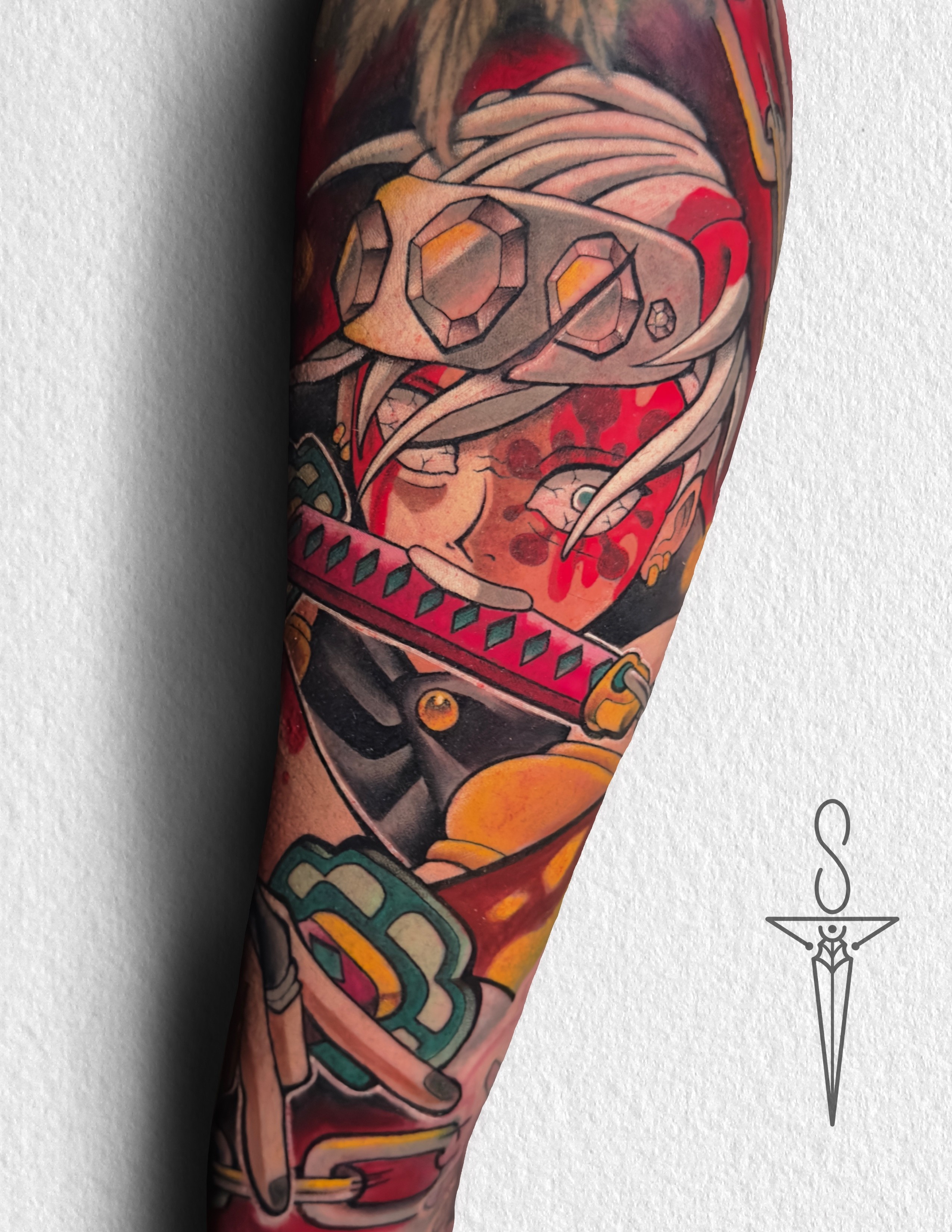 A vibrant tattoo of a chainsaw-like creature on a person's forearm. The tattoo is detailed with shades of orange, black, teal, and red.