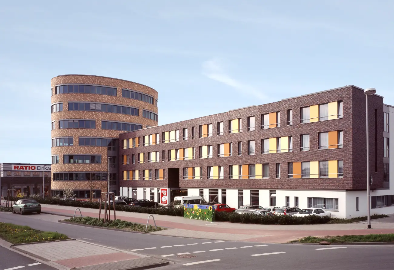 Isometrische Zeichnung eines Bauprojekts mit mehreren Gebäuden und markierten Strukturen in Rot