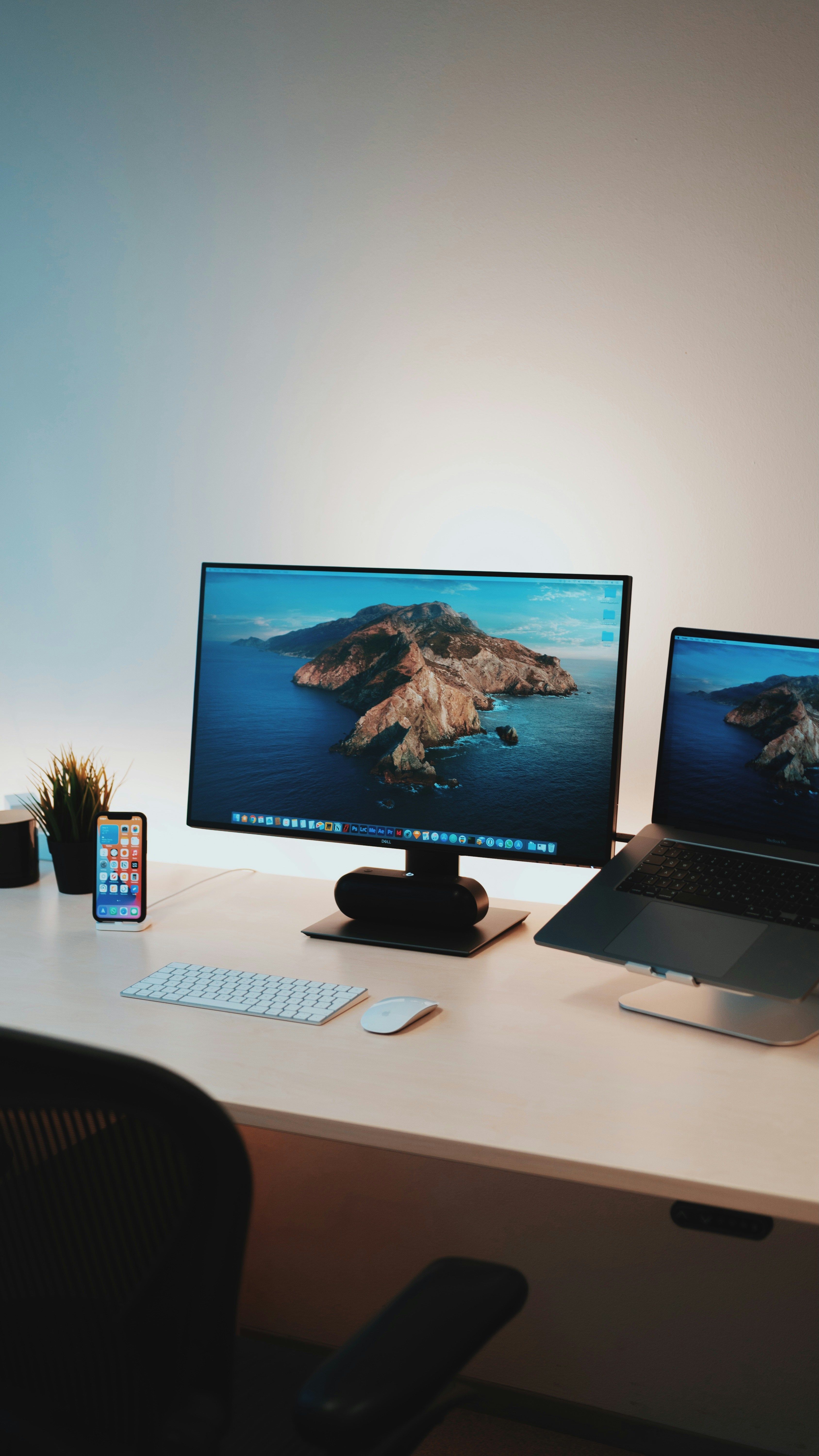 A picture of a desktop beside a laptop on a desk