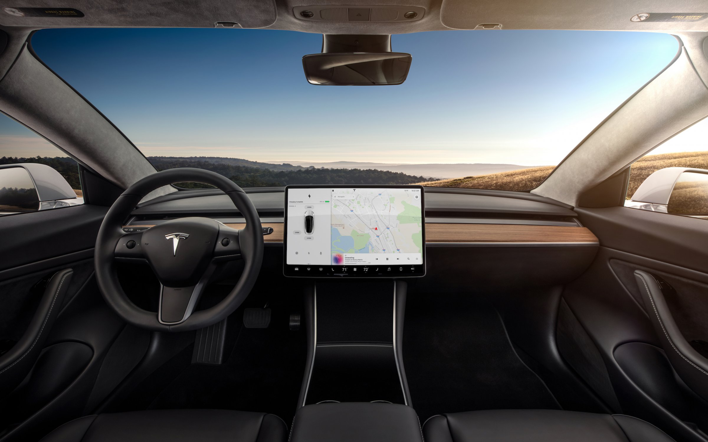 Habitacle de la Tesla Model 3 avec grand écran central, design minimaliste et vue panoramique vers l’avant
