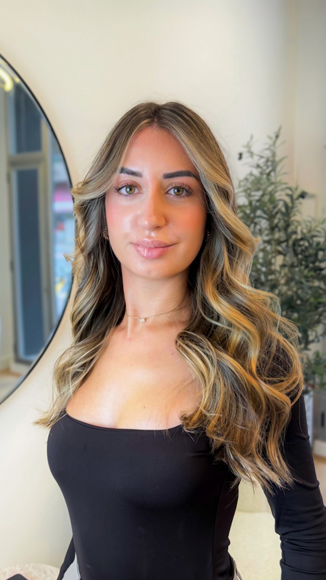 A wooden essential oil diffuser releasing a gentle stream of steam, surrounded by dried herbs and a small bottle of essential oil. The warm lighting enhances the cozy and therapeutic ambiance.