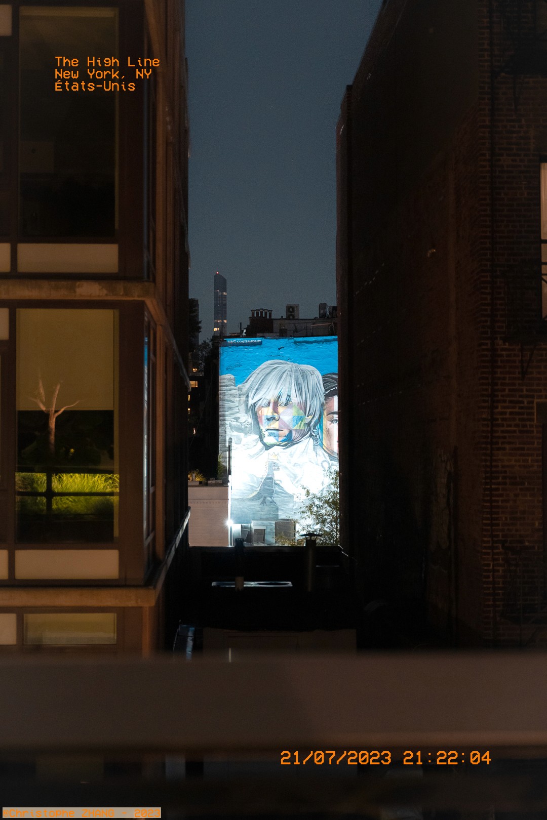 Mural coloré visible de nuit depuis la High Line, entouré d'architectures dans la nuit.
