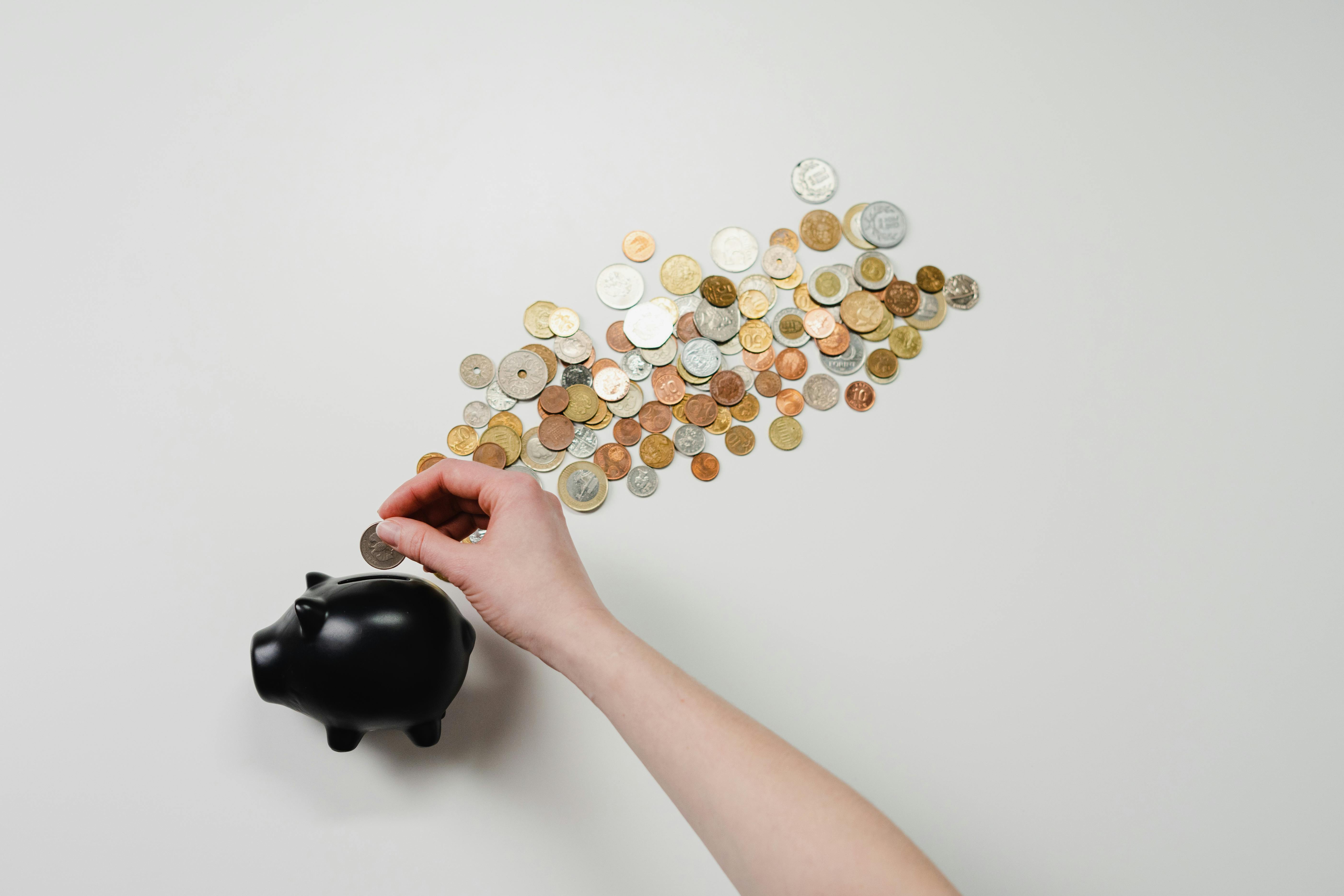 Piggy bank with coins spilled out on table