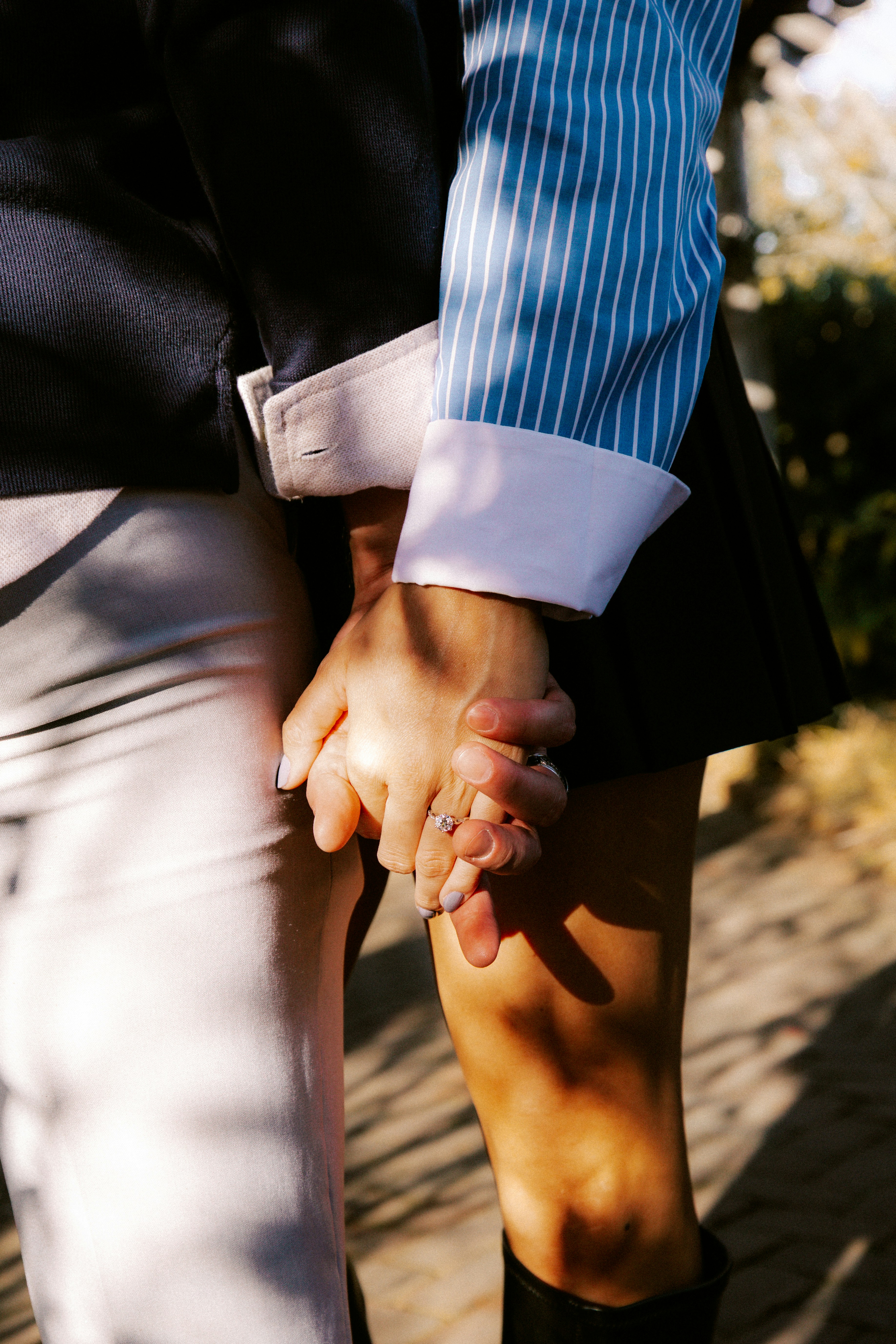 Two people holding hands outdoors