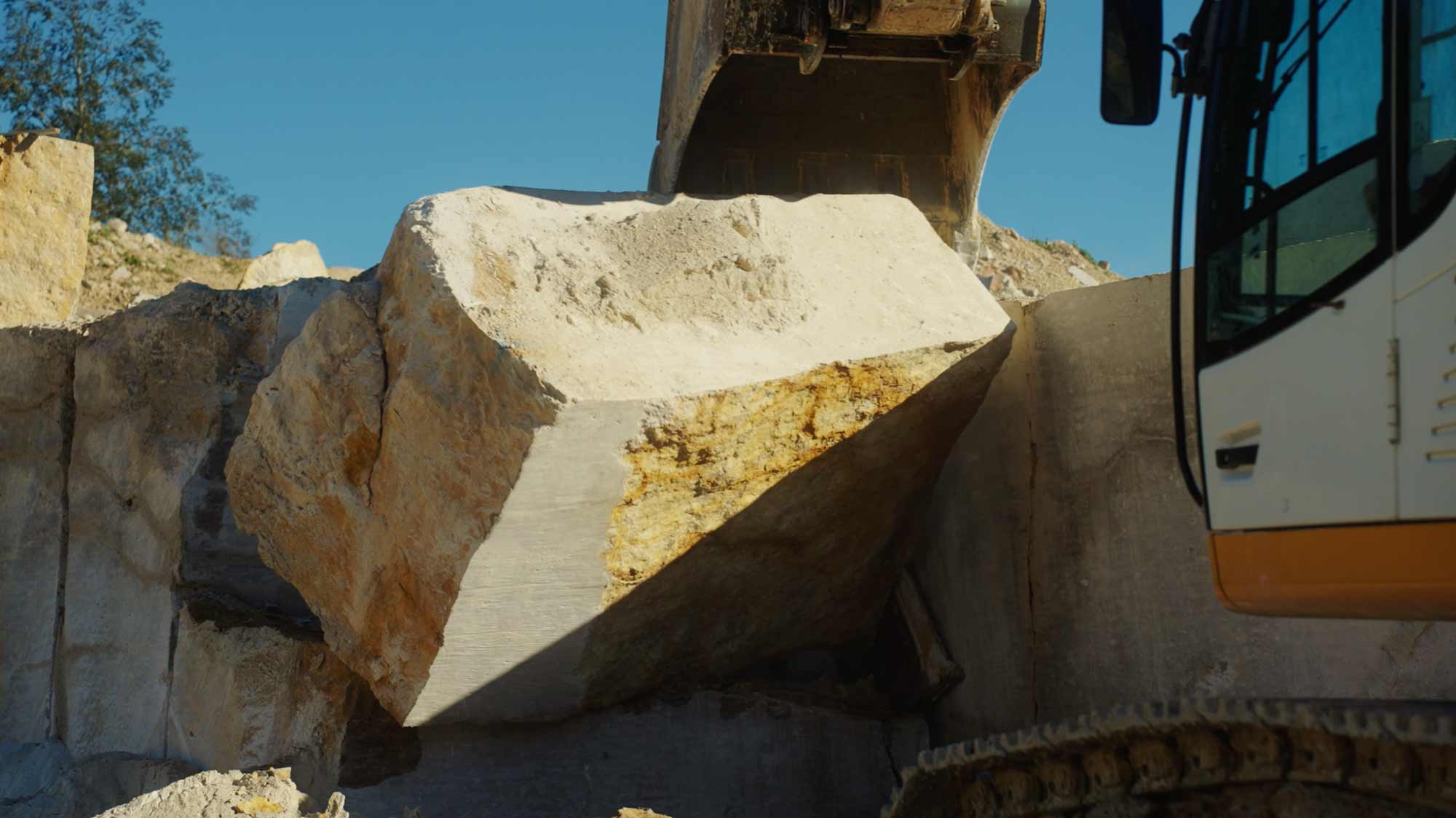 Bulldozer moves large rock, illustrating strategic filmproduction for brand storytelling and advertising campaigns.