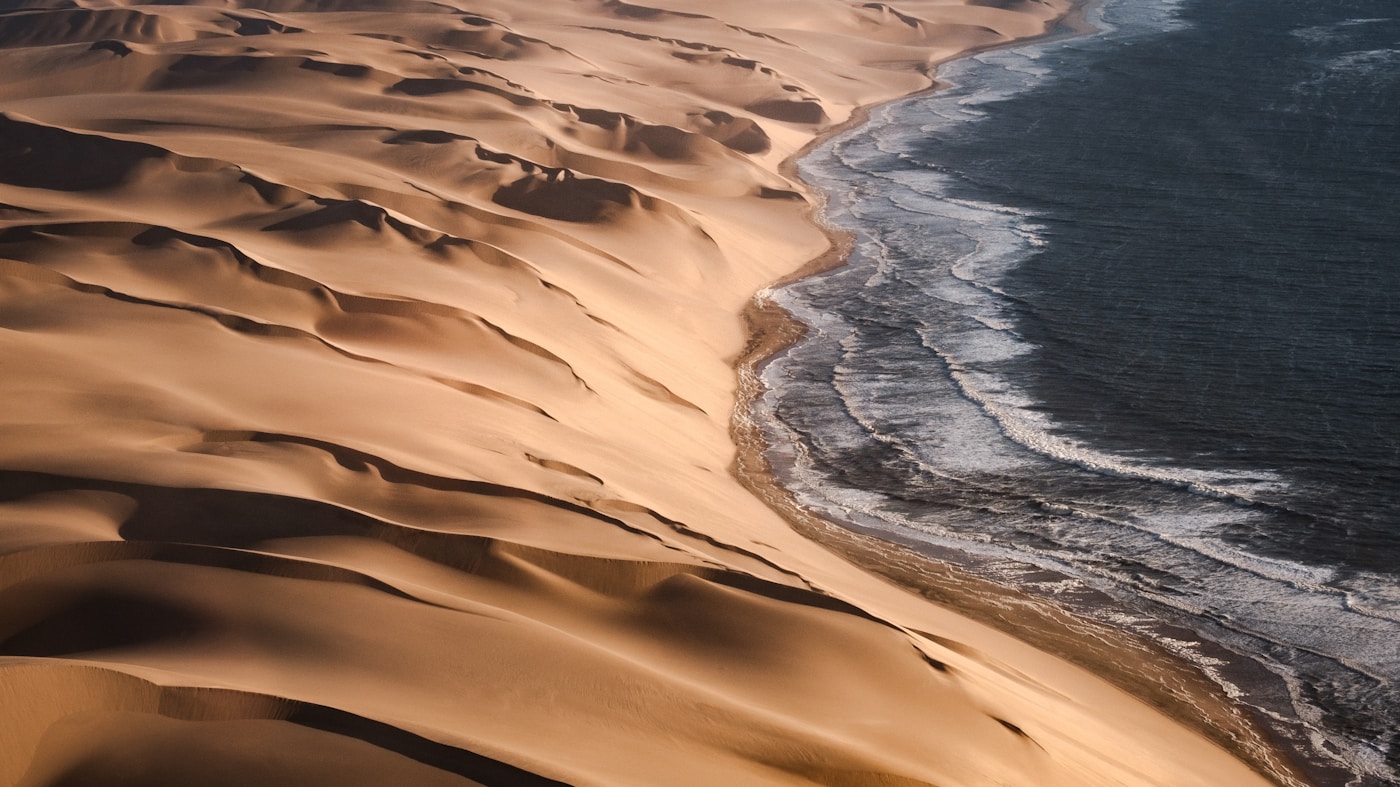 Sand dunes meeting the Atlantic Ocean at Sandwich Harbour, Namibia