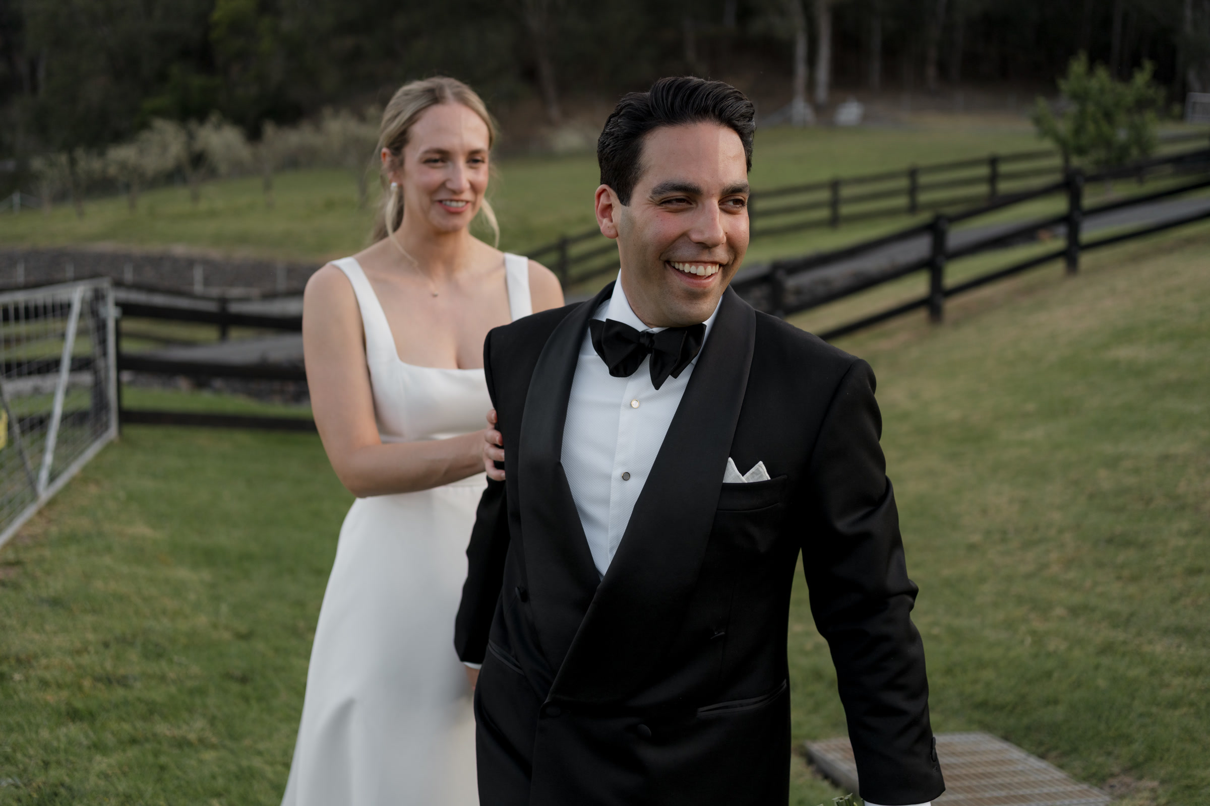 Bride walking behind a laughing groom during relaxed wedding portraits