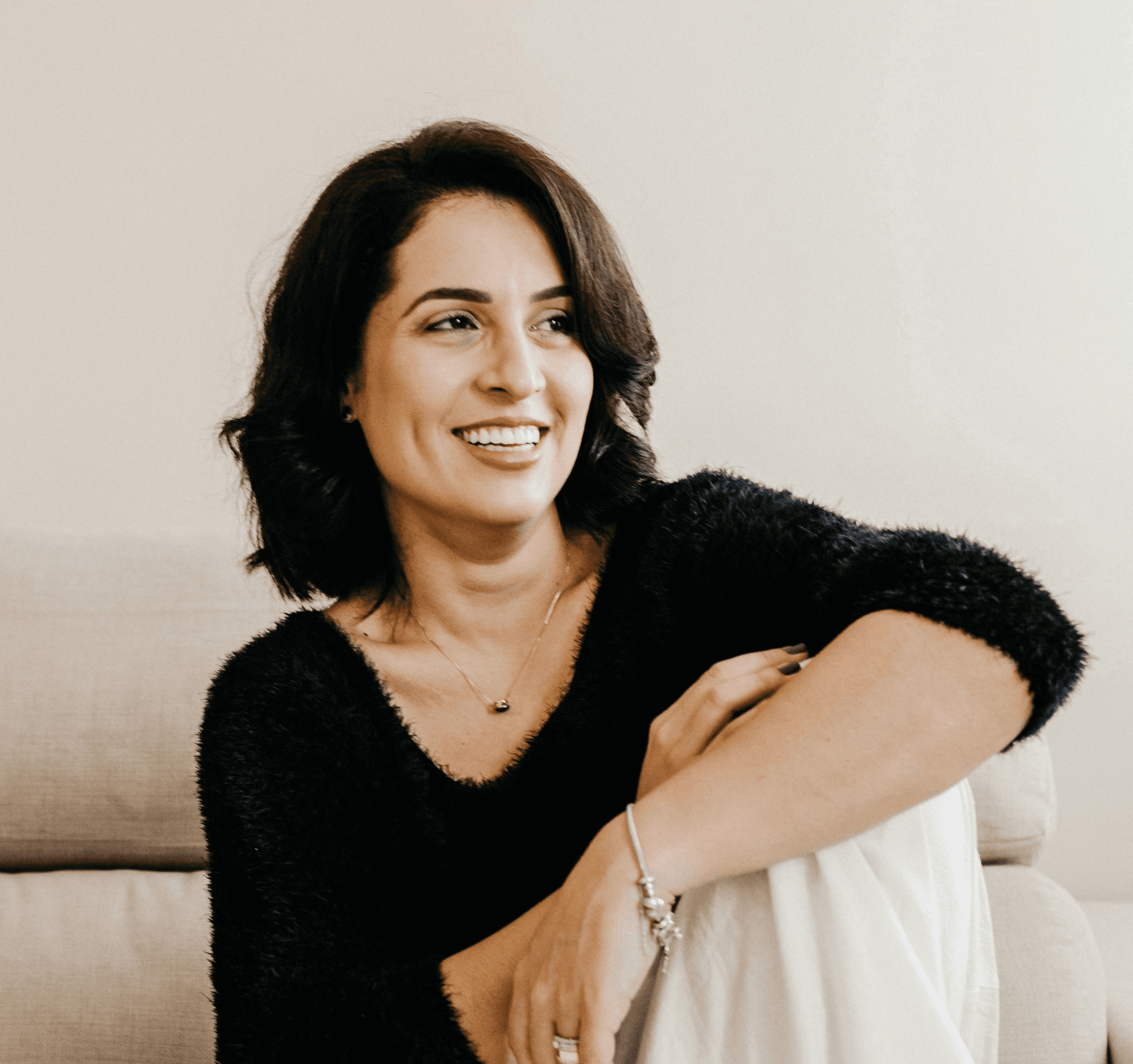woman in black long sleeve shirt sitting on white couch