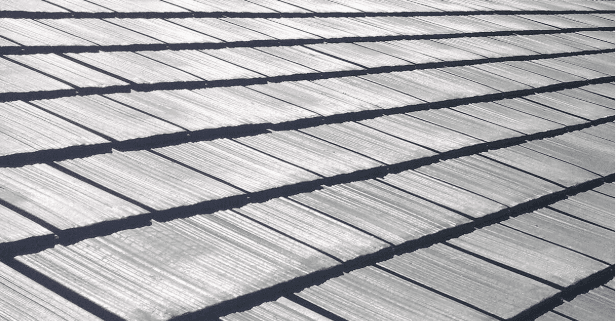 a man in a yellow shirt is working on a roof
