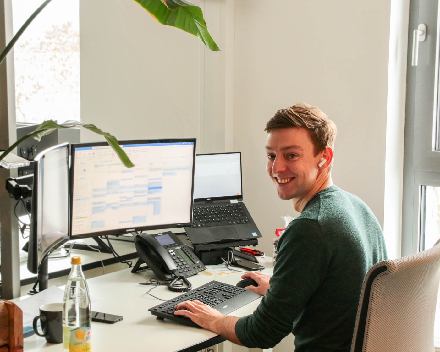 Andre Unkrig, Geschäftsführer von rankk, lacht in die Kamera während er an seinem Schreibtisch sitzt.