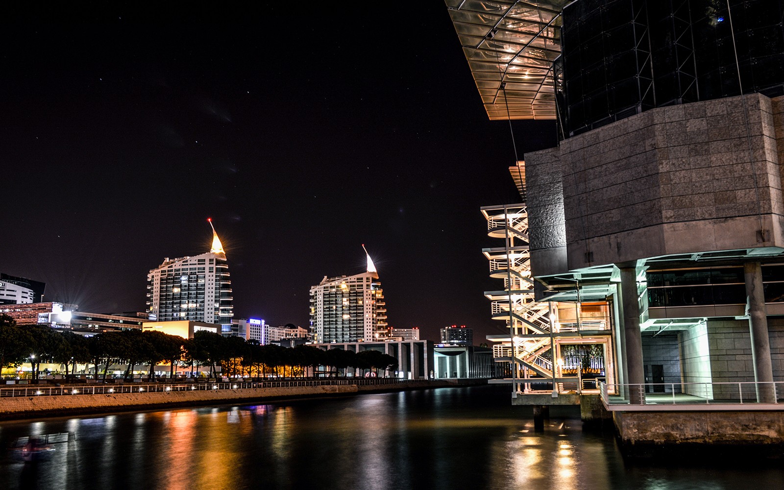Horizonte noturno de Lisboa com edifícios iluminados e vista para a orla durante um cruzeiro de 2 horas.