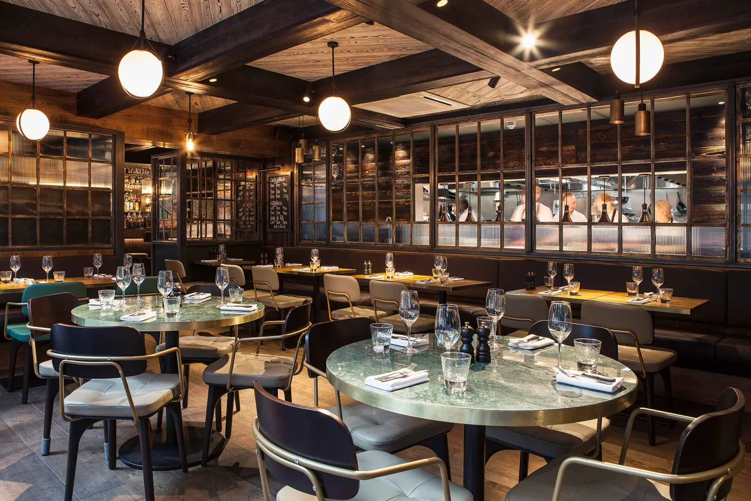 Inside The Coal Shed restaurant near London Bridge, featuring marble tables and an open kitchen set for Sunday lunch.
