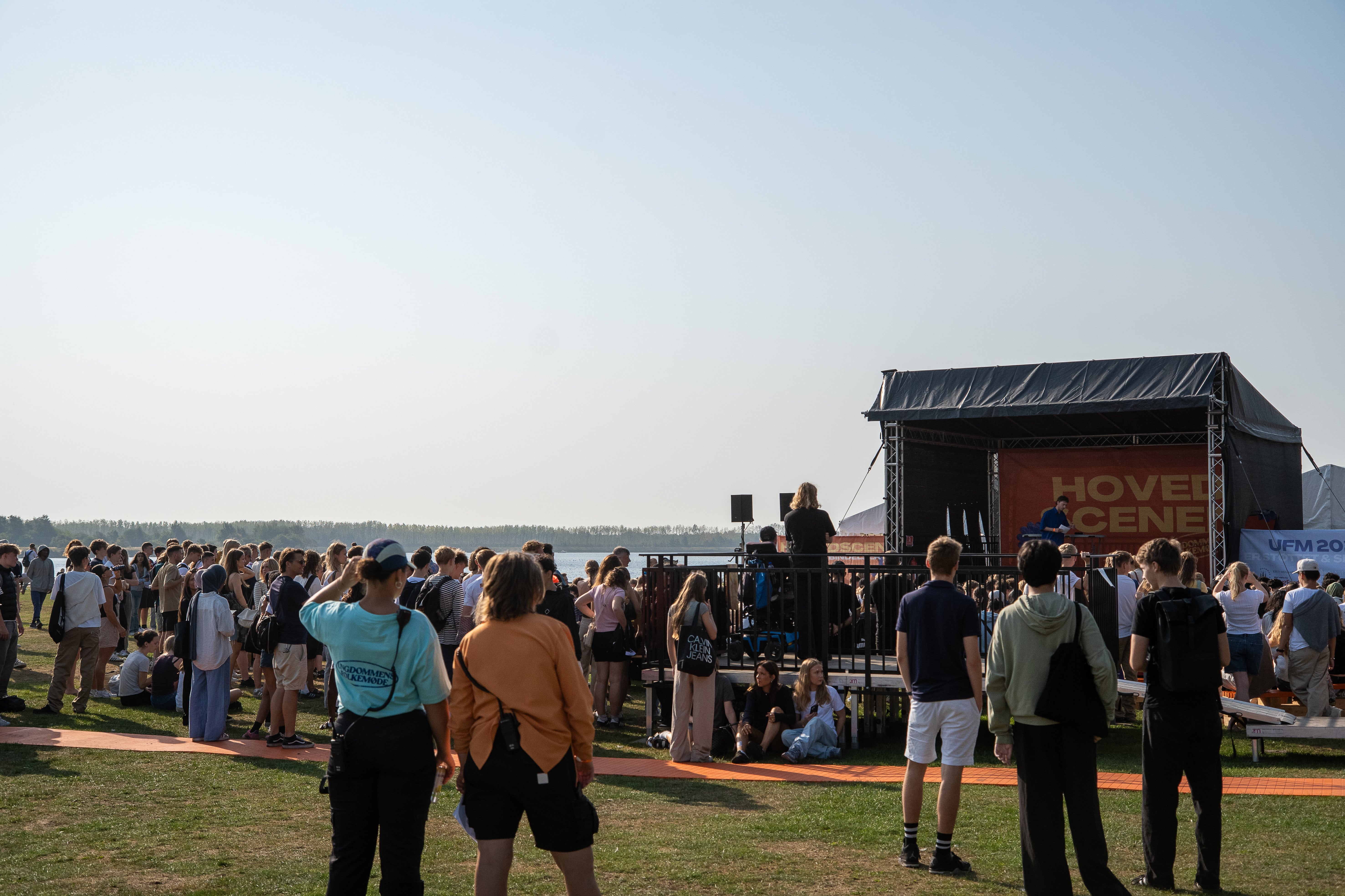 Frivillige og publikum, der oplever en debat under åben himmel til Ungdommens Folkemøde. 