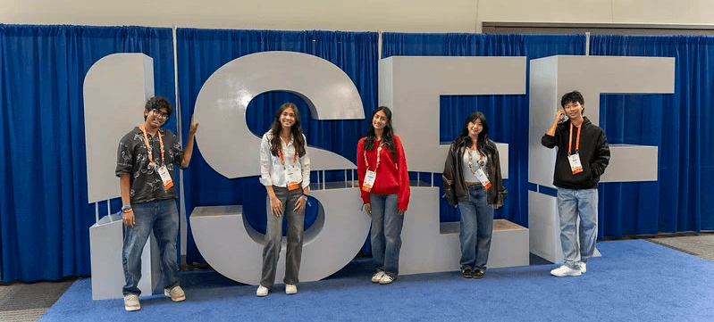 four qualified for isef students in front of the isef sign