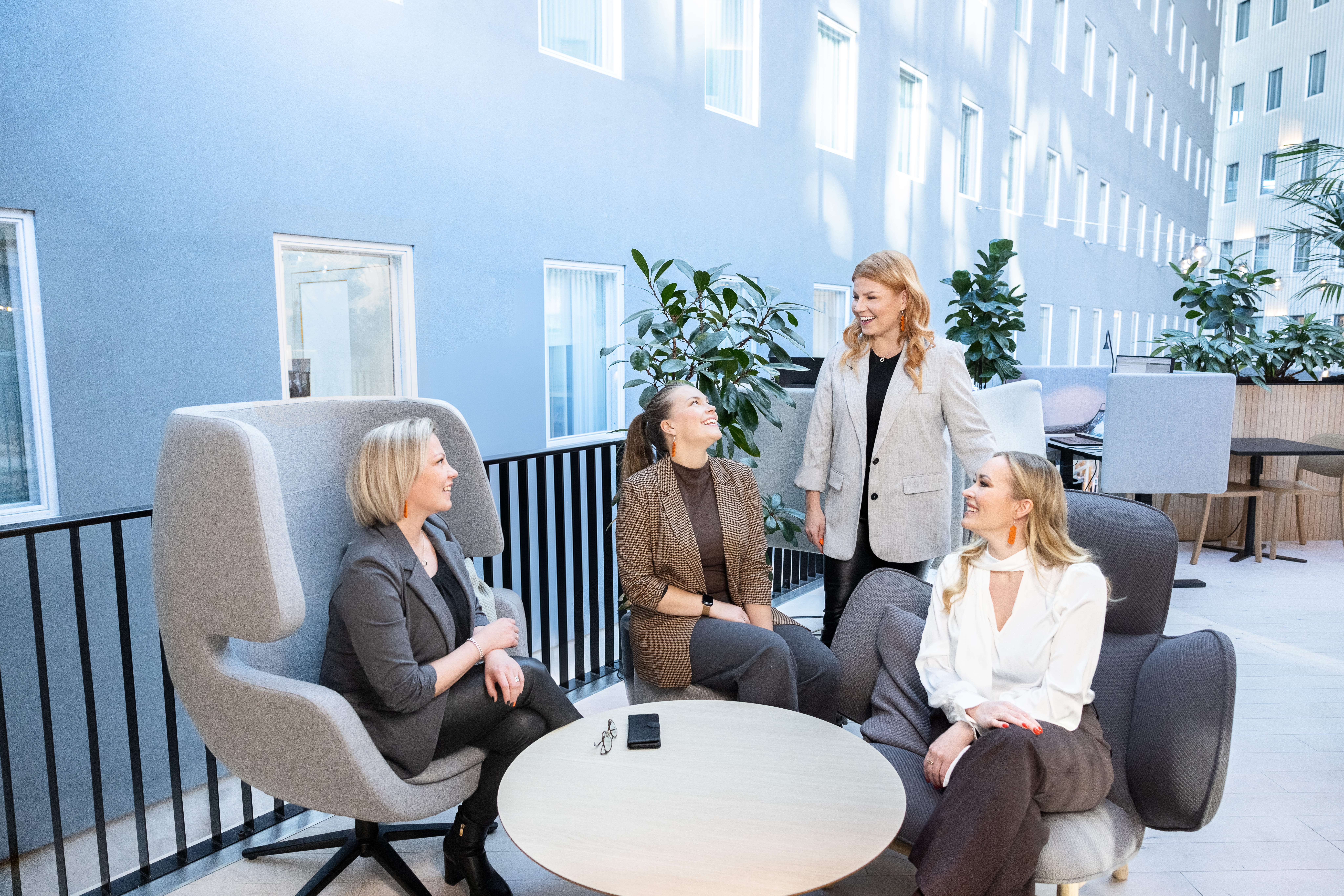 Network & Growthin valmentajatiimi keskustelee modernissa toimistoympäristössä; sparraava ja avoin työpajatunnelma.