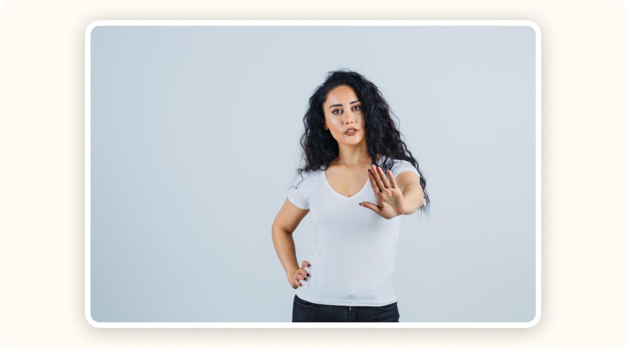 Femme levant la main devant elle pour faire un geste d’arrêt.