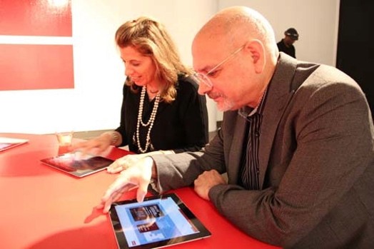 Two people sitting at the table watching content on a tablet