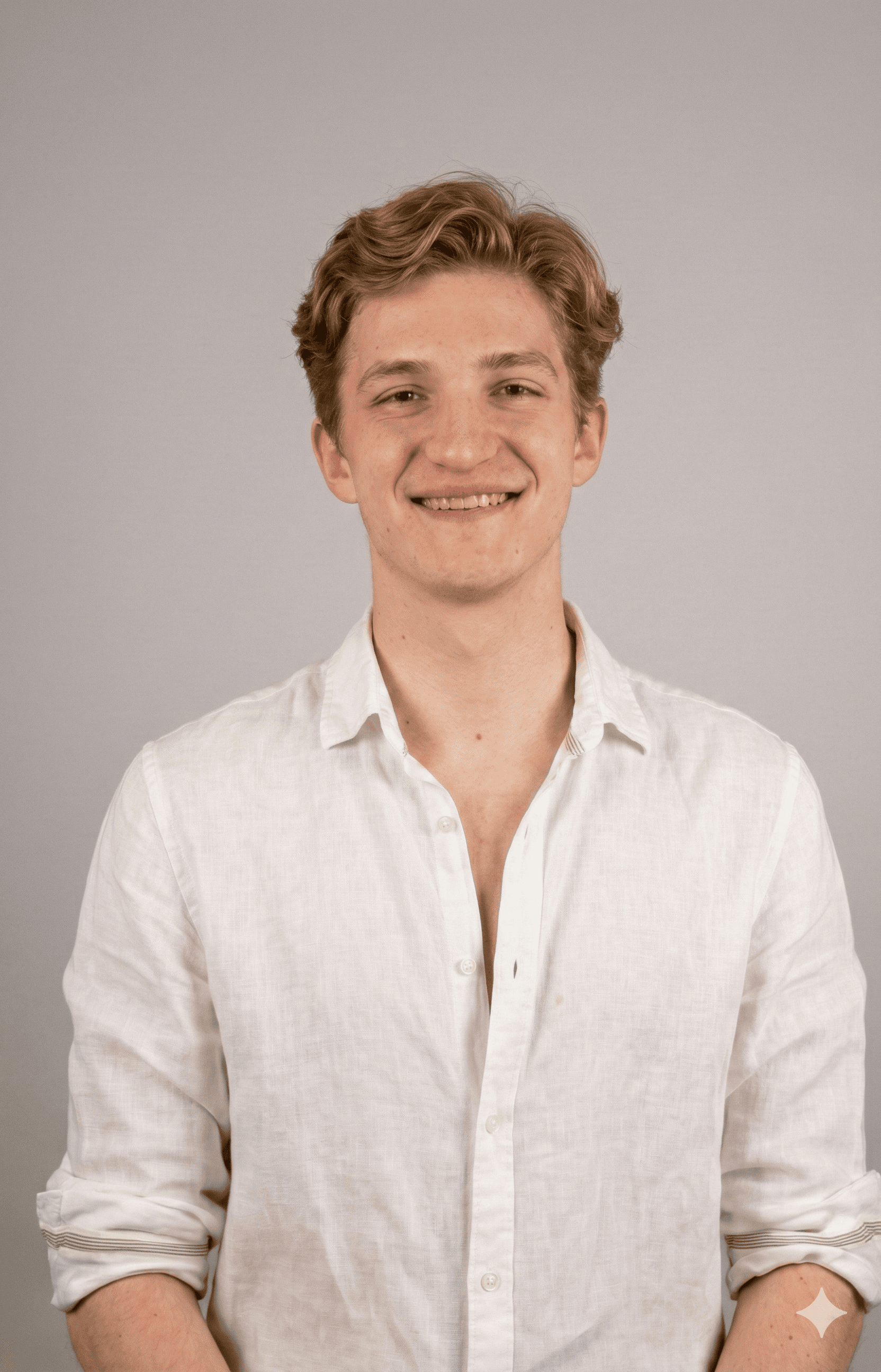 Portrait of a laughing person with curly hair wearing a white shirt