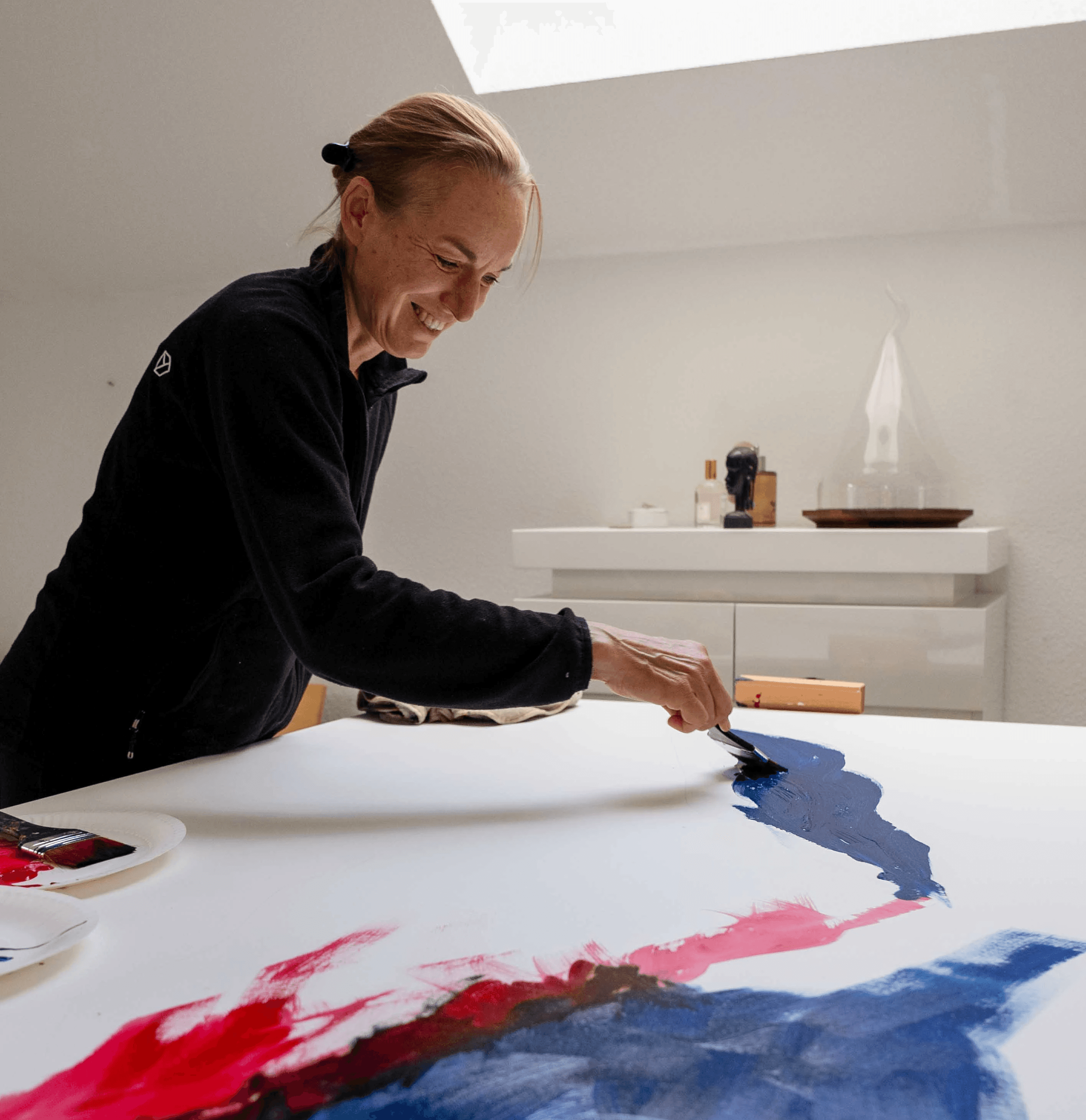 Künstlerhand arbeitet an abstraktem Gemälde auf Leinwand im Atelier