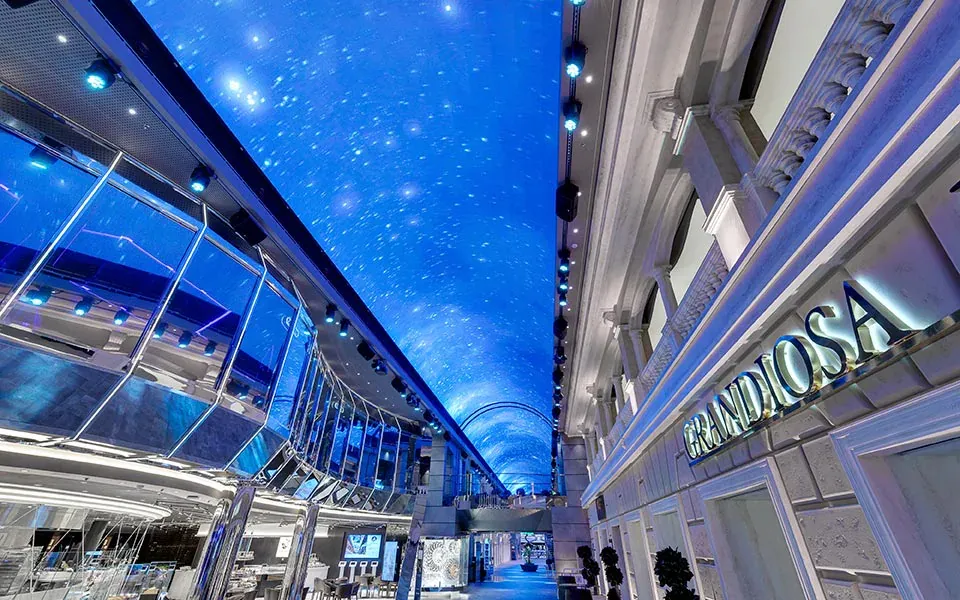 Galeria interna do navio MSC Grandiosa com teto iluminado