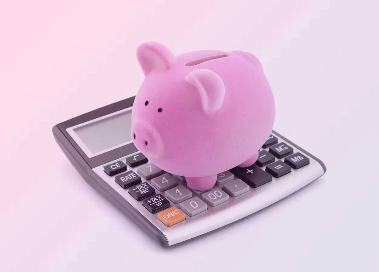 image shows a piggy bank and calculator to symbolize how to get paid faster as a freelancer